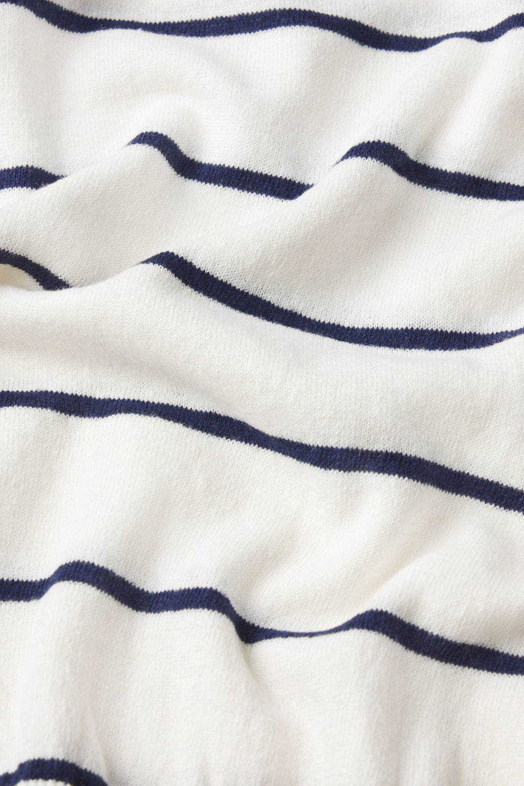 Close-up of the Evaline Sweater in English Navy Fisherman, showcasing evenly spaced navy stripes on white fabric with a slightly wrinkled texture.