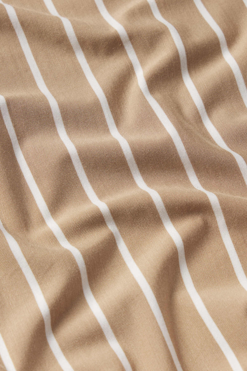 A close-up shows beige fabric with white, evenly spaced vertical stripes and subtle wrinkles, just like the Sandstone Vertical Stripe pattern featured in the DreamModal Kimono Shorts Bundle.