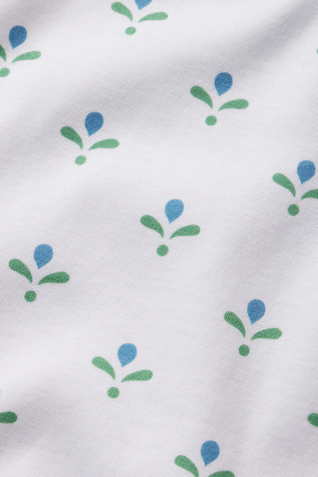 The Pima Crew Wide Leg Pajama Set in Serene Blue Multi Blossom features white Pima cotton with a repeating pattern of simple green and blue floral shapes, each motif displaying a blue teardrop above two green leaves and a green oval below.