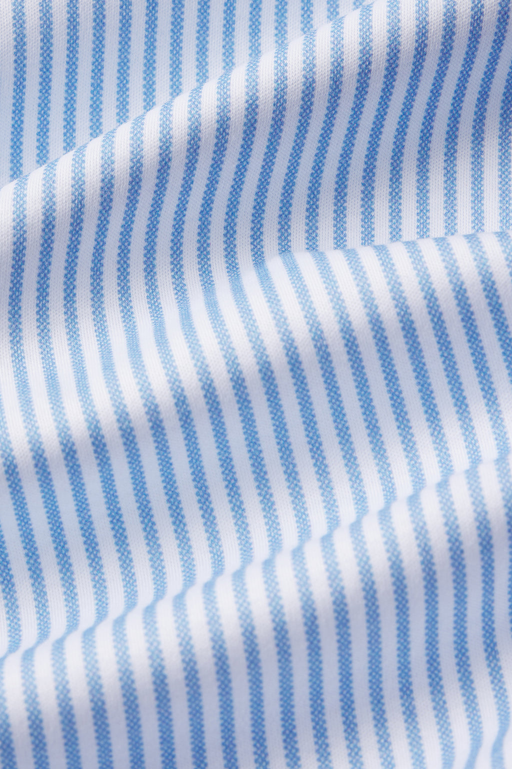 Close-up of the Pima Long-Long Set in Classic Blue Oxford Print, featuring soft white Pima cotton with thin blue vertical stripes and gentle folds that add subtle texture.