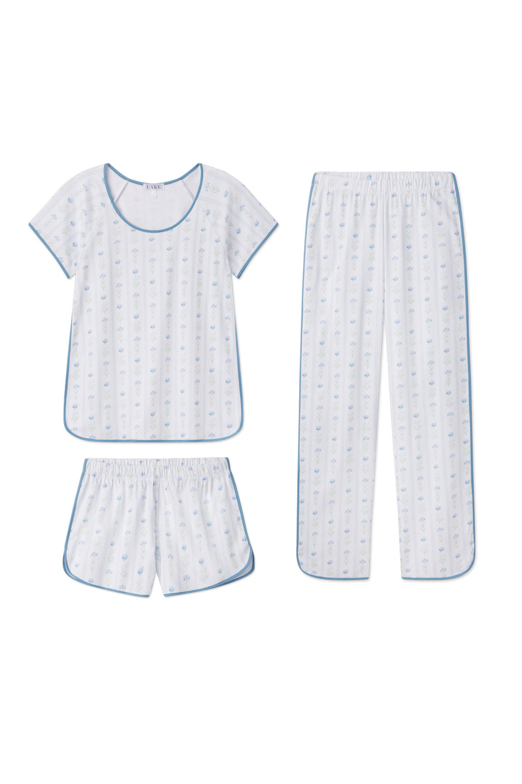 The Pima Bundle in Serene Blue Watercolor Stems includes a white short-sleeve top with blue trim, plus matching long pants and shorts—all crafted from Pima cotton in a tranquil watercolor floral pattern.