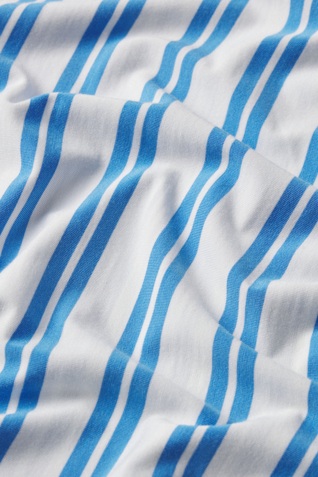 White fabric with blue Regatta Stripe, shown with gentle folds and soft shadows. Featured: DreamModal Daydream Shorts Set in Regatta Stripe.
