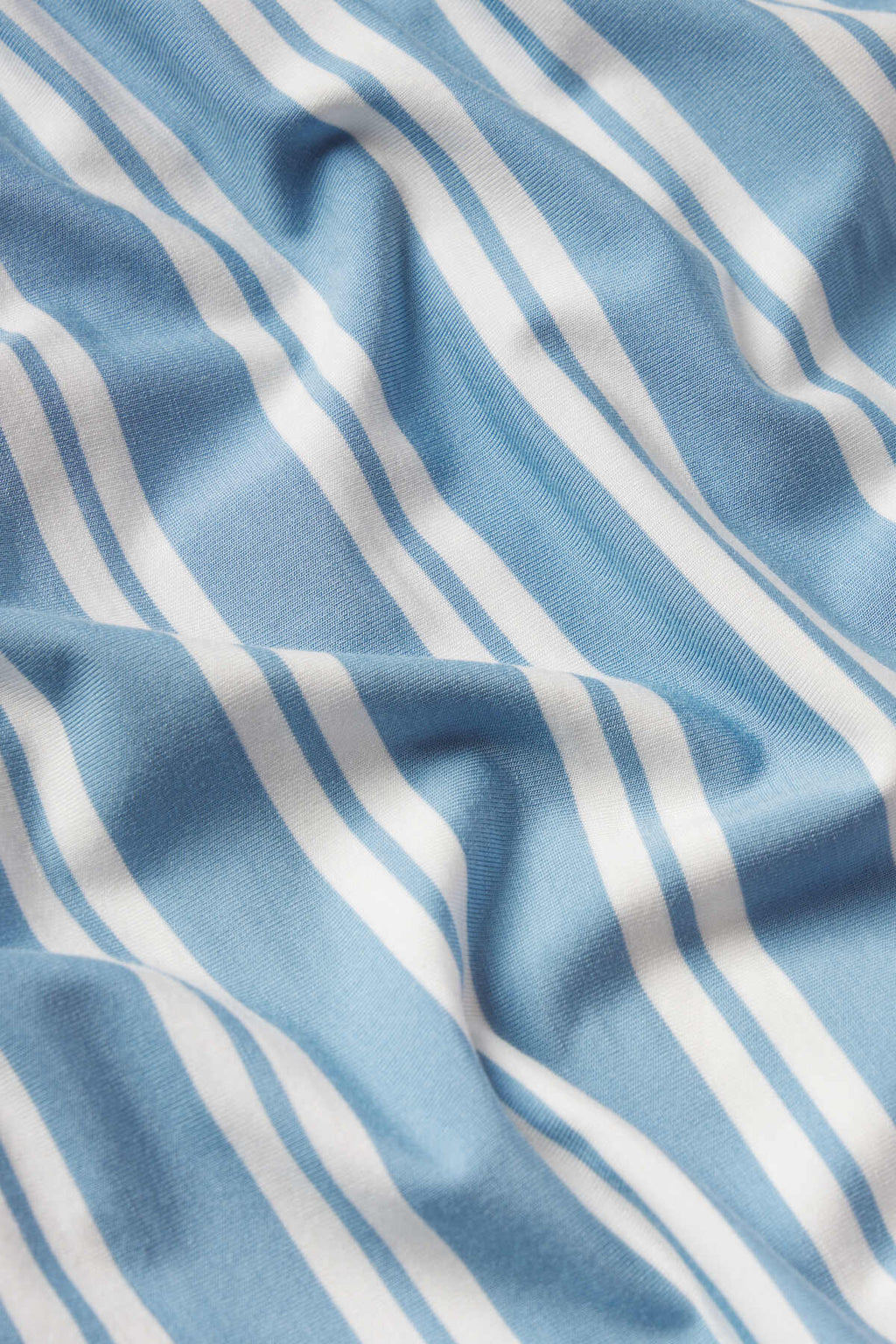 A close-up of the DreamModal Daydream Pants Set in Serene Blue Stripe, featuring soft fabric with white wavy stripes and gentle folds—ideal for a cozy pajama look.