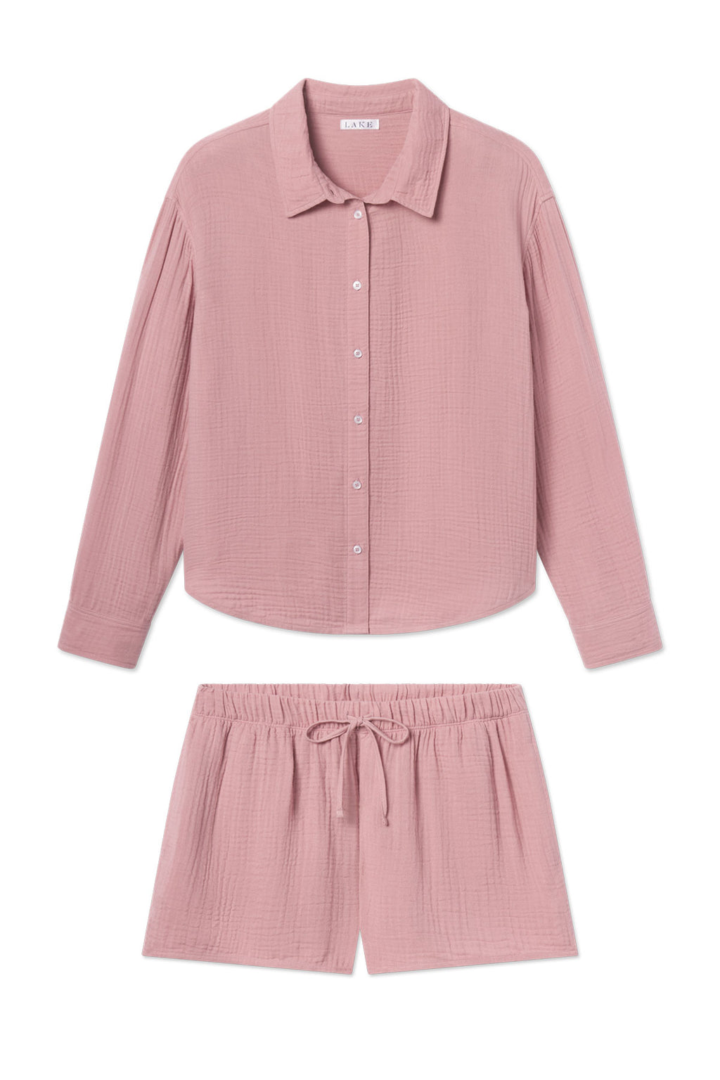 The Nantucket Shorts Set in Carnation is a light pink loungewear ensemble with a long-sleeve button-up shirt and drawstring Cotton Gauze shorts, both featuring soft, textured fabric and a relaxed fit.
