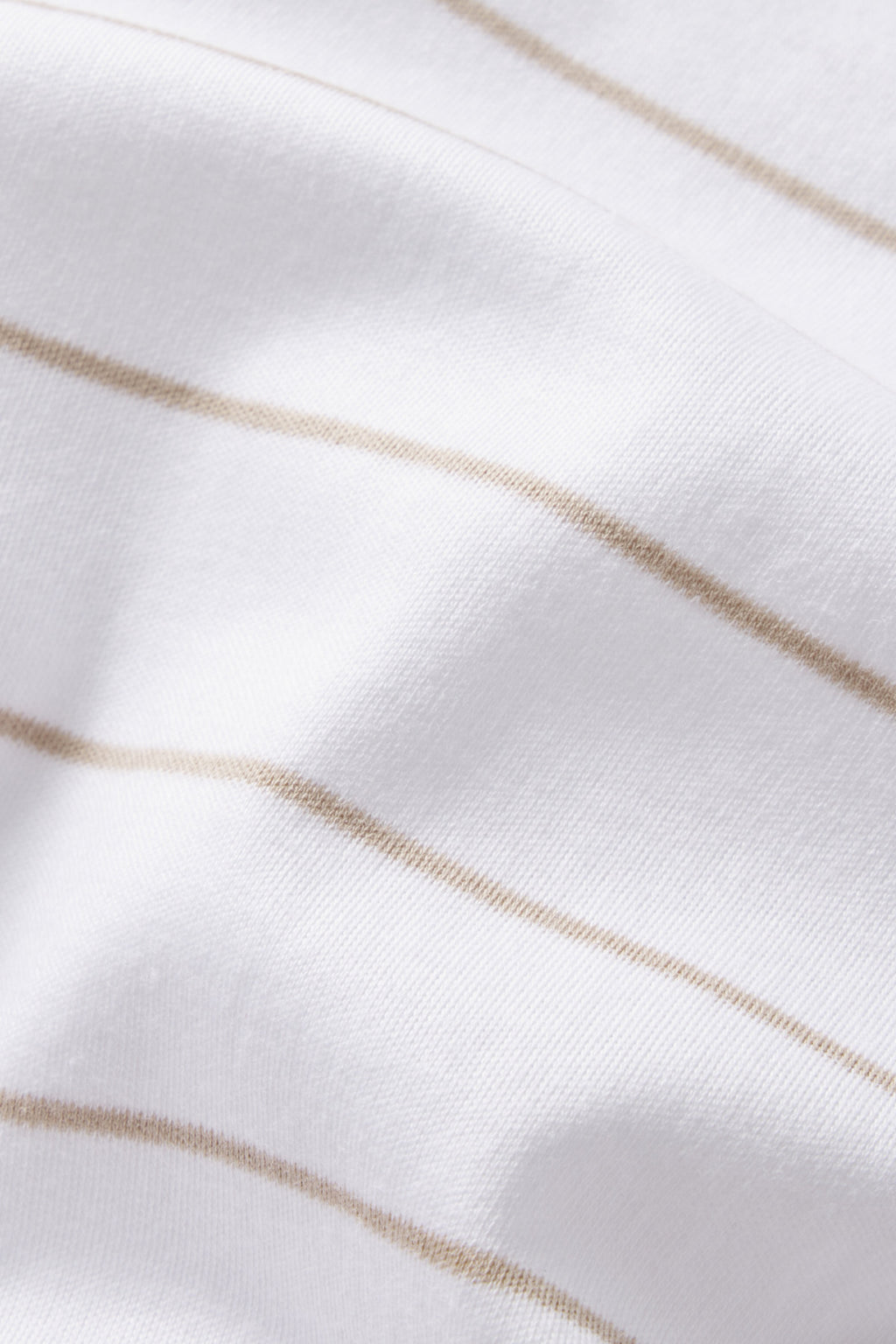 Close-up of the Pima Short-Long Set in Driftwood Stripe, showcasing soft white Pima cotton fabric with thin, light beige horizontal stripes and gentle curves that create subtle shadows.