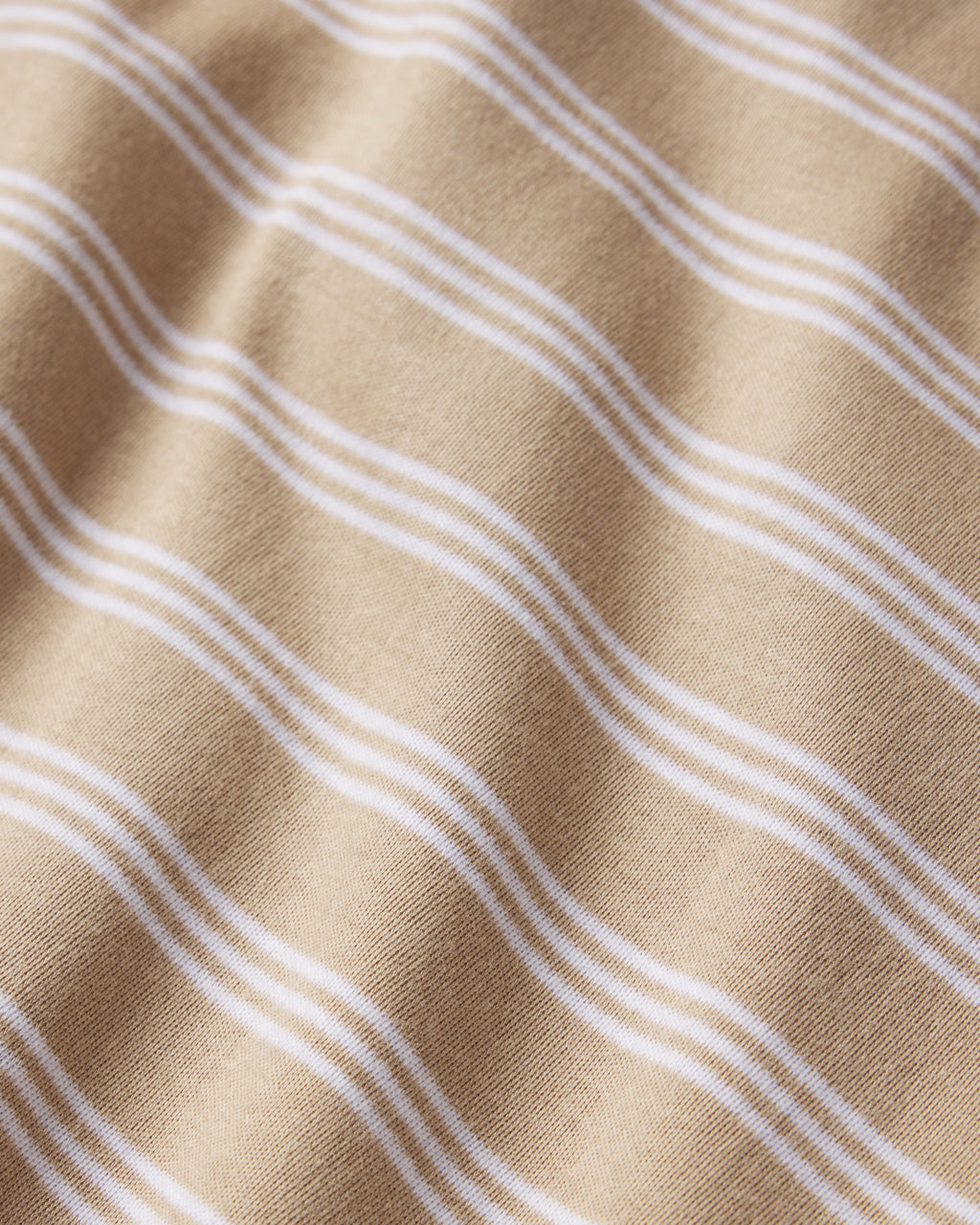A close-up of the Pima Crew Wide Leg Pajama Set in Sandstone Mixed Stripe shows soft beige Pima cotton with wavy white stripes, delicate folds, and textured detail—perfect for cozy comfort and relaxed style.