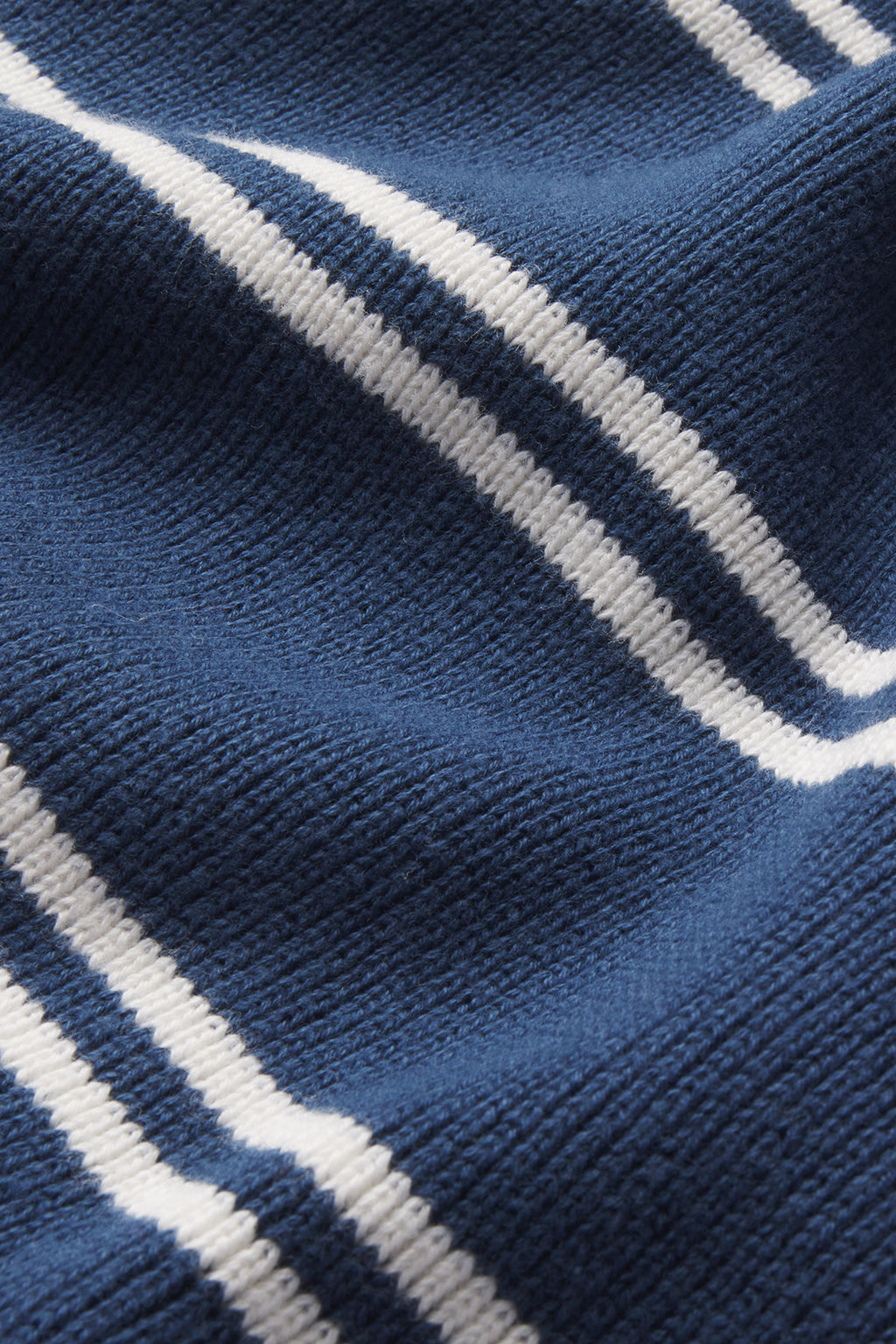 A close-up of textured navy blue fabric with white stripes, highlighting the soft weave—ideal for the Nora Cotton Cardigan in Navy Ivory Stripe or achieving a classic varsity sweater style.
