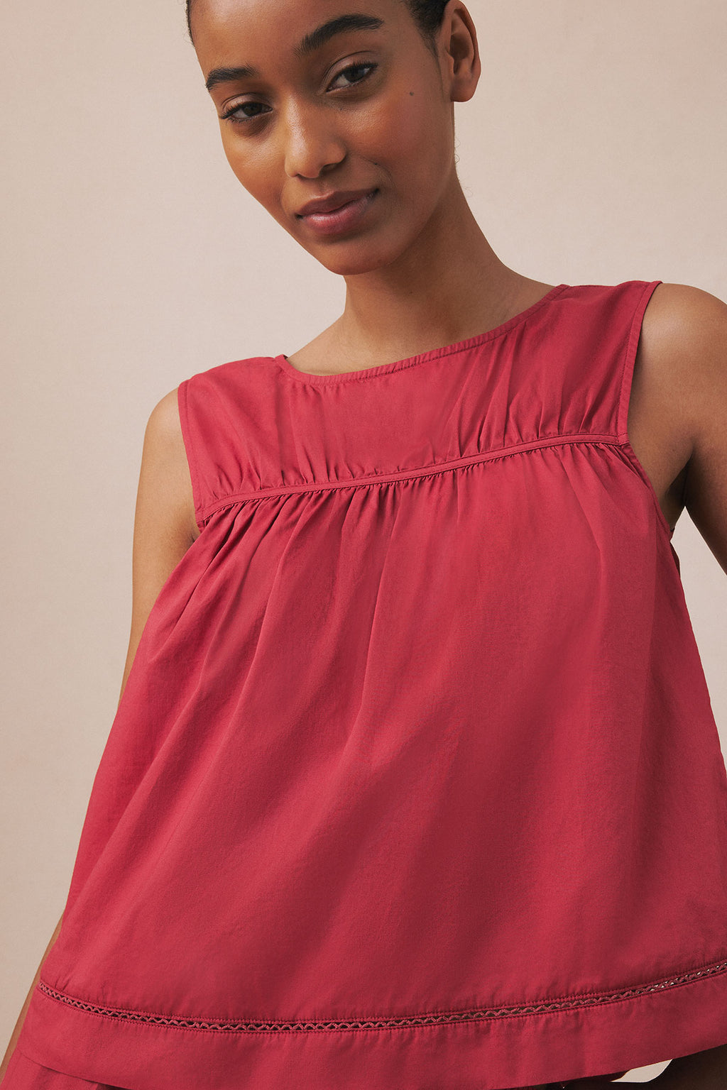 Bordeaux sleeveless tank top with gathered yoke detail and decorative stitching at hem.