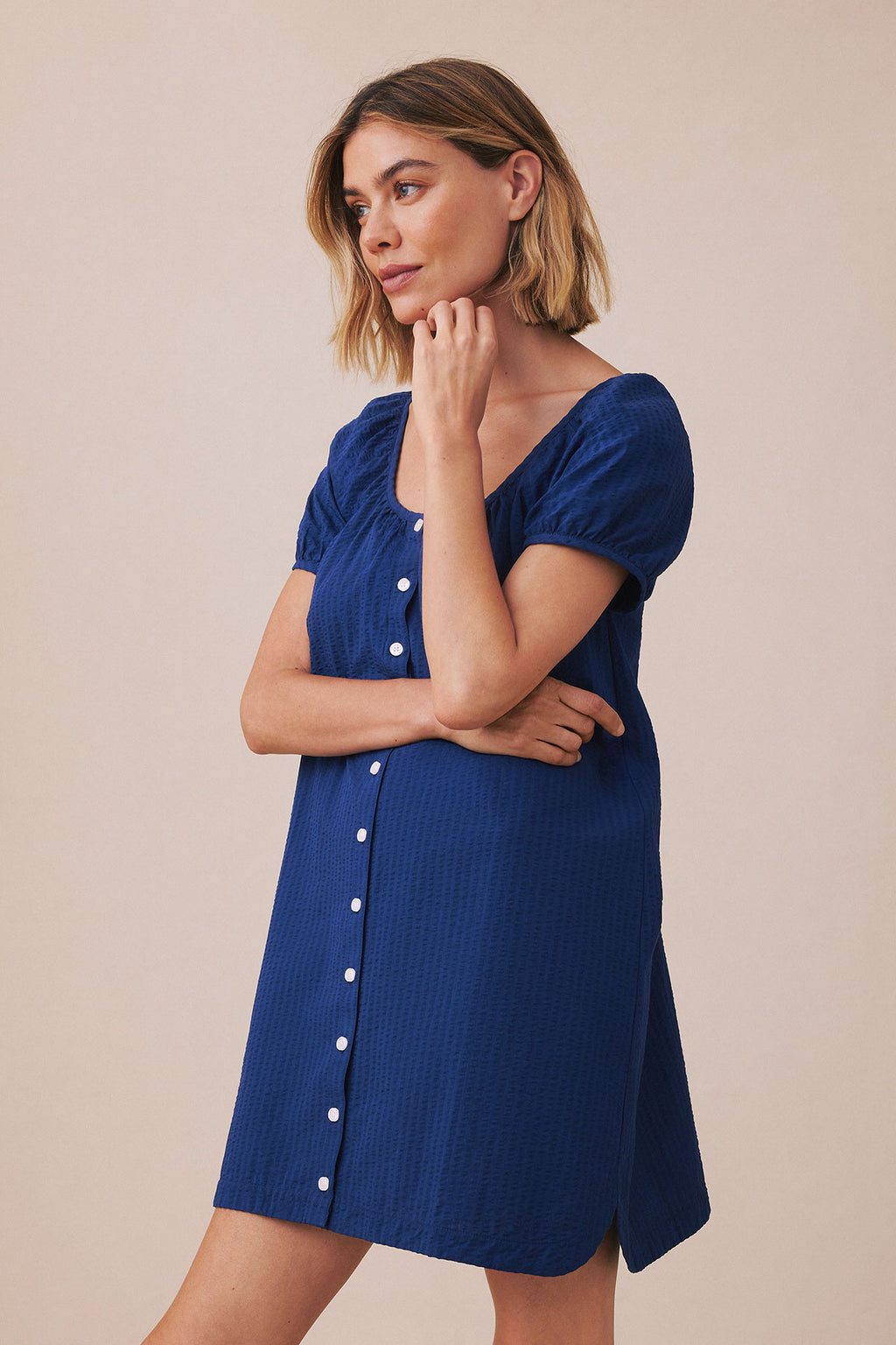 Blue seersucker nightgown with short puffed sleeves, V-neckline, and white button front closure.