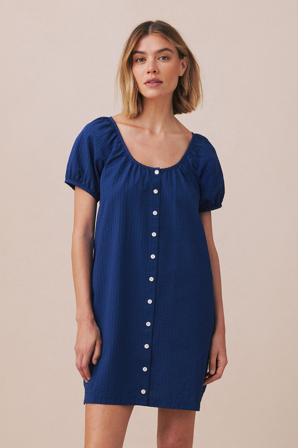 Blue seersucker nightgown with short puffed sleeves, scoop neckline, and white button front closure.