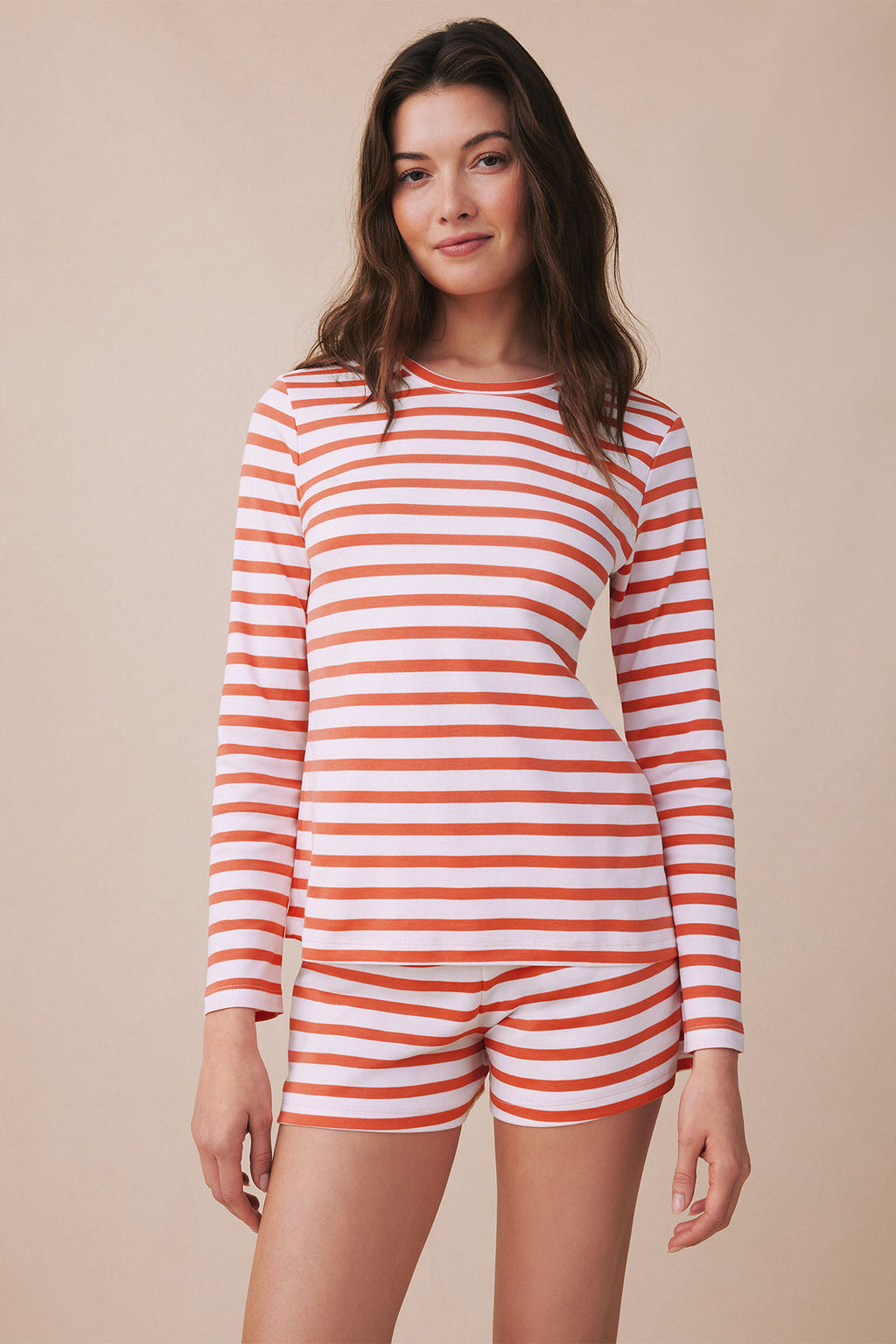 Woman wearing red and white striped long-sleeve crew top and matching shorts.