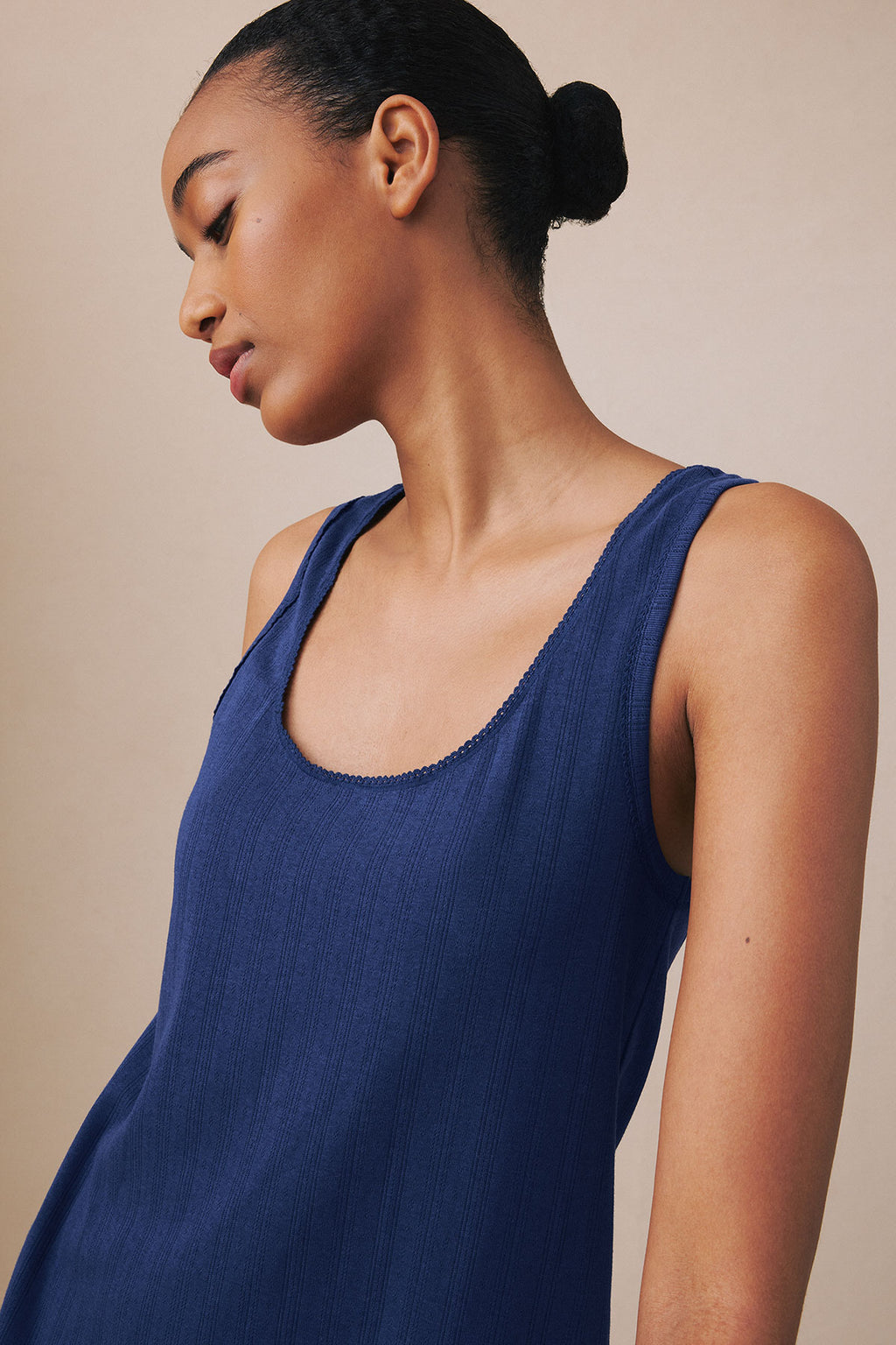 Dark blue ribbed tank top with scoop neckline and pointelle texture detail on the neckline.