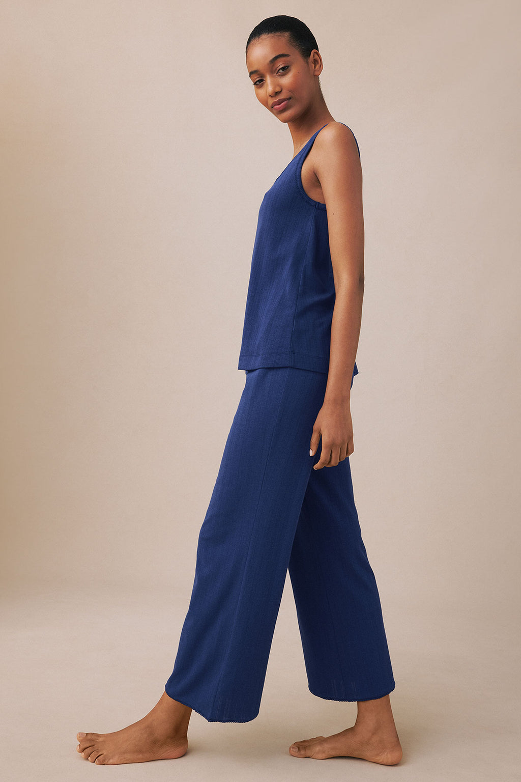 Woman wearing a blue pointelle sleeveless tank top and matching wide-leg cropped pants.