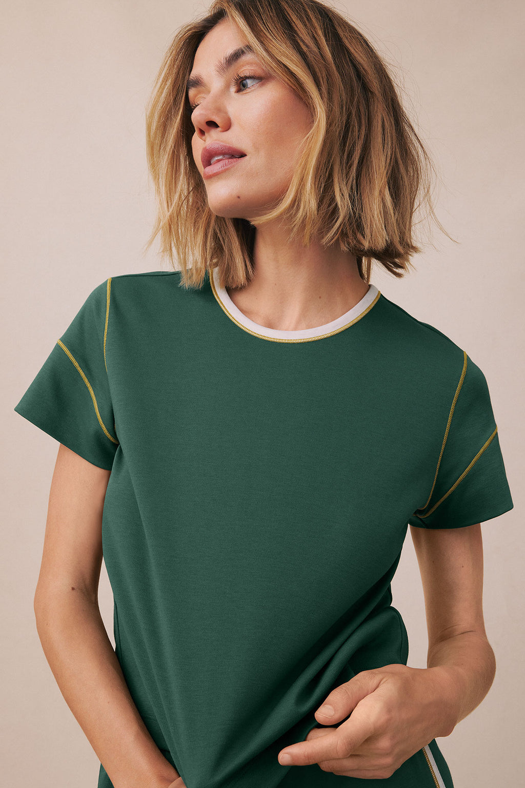Trekking green short-sleeve t-shirt with white and gold trim at neckline and gold seaming detail on sides.