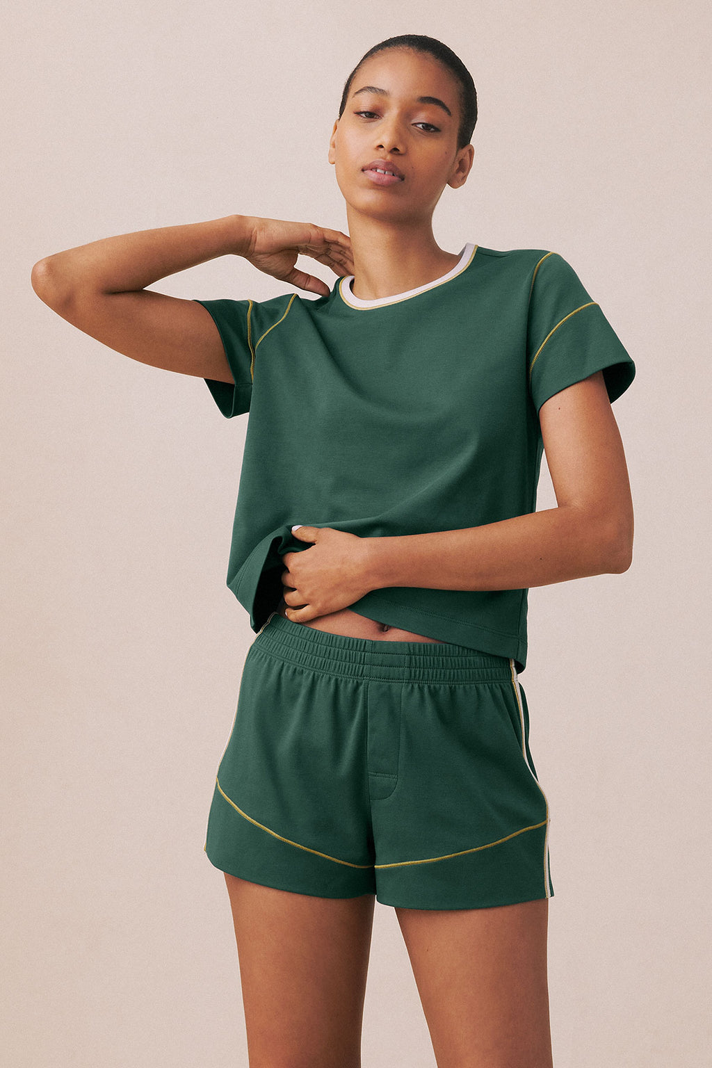 Trekking green t-shirt and shorts set with white neck trim and gold curved piping details on sleeves and legs.