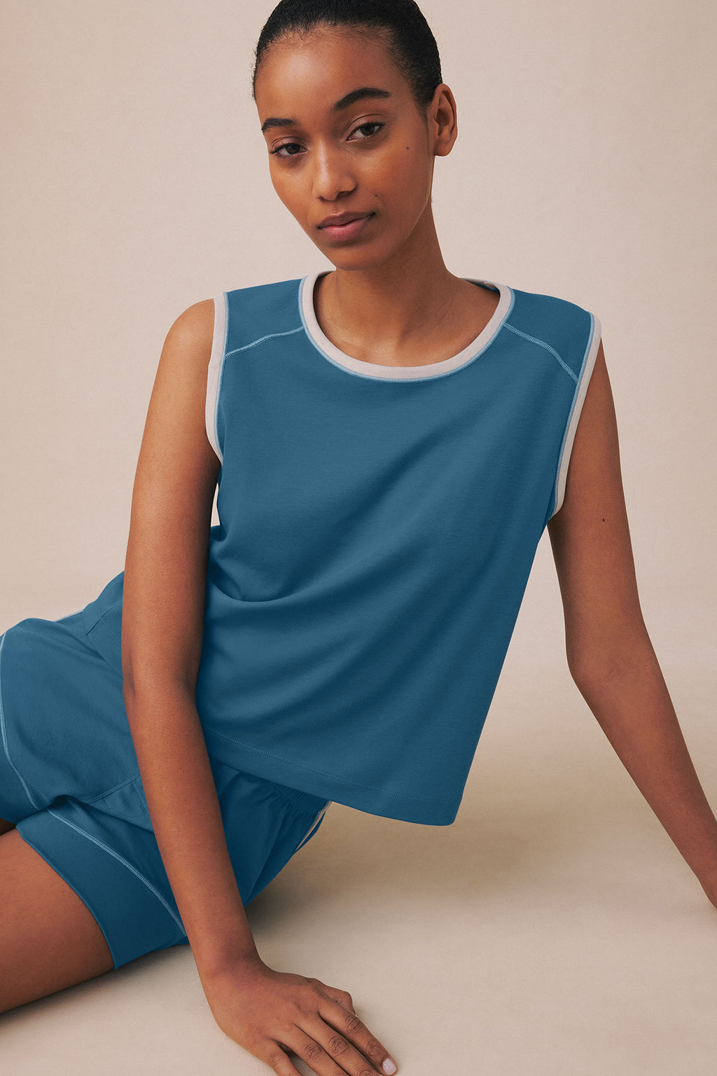 Blue sleeveless tank top and matching shorts with white trim, displayed on model.