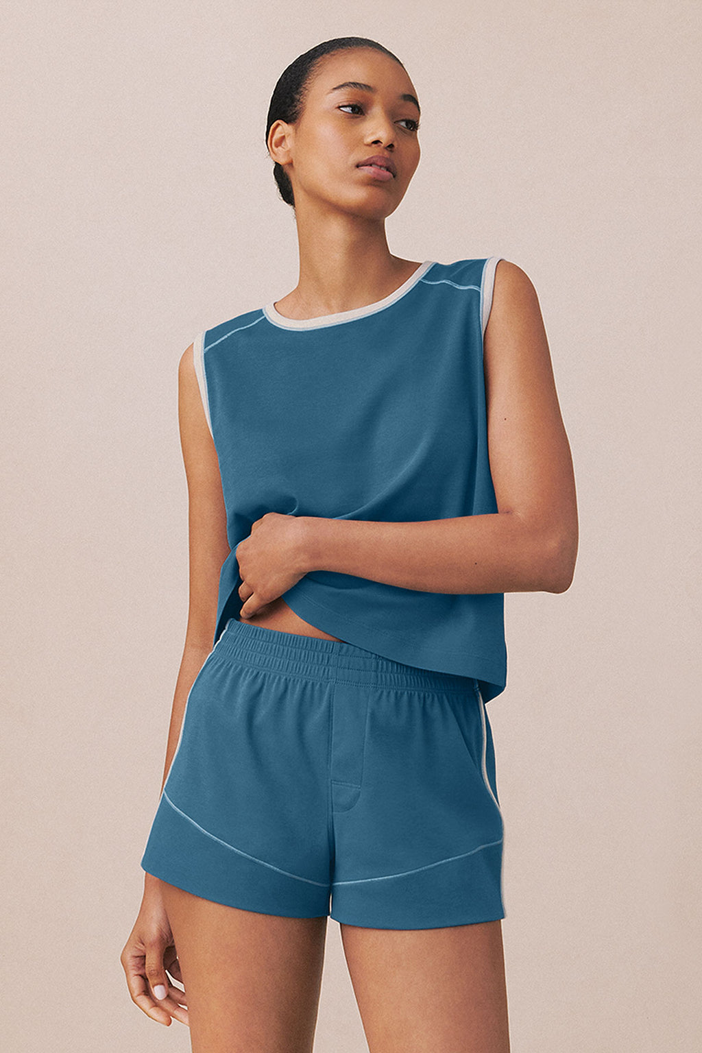 Blue sleeveless tank top with white trim and matching blue shorts with contrast stitching.