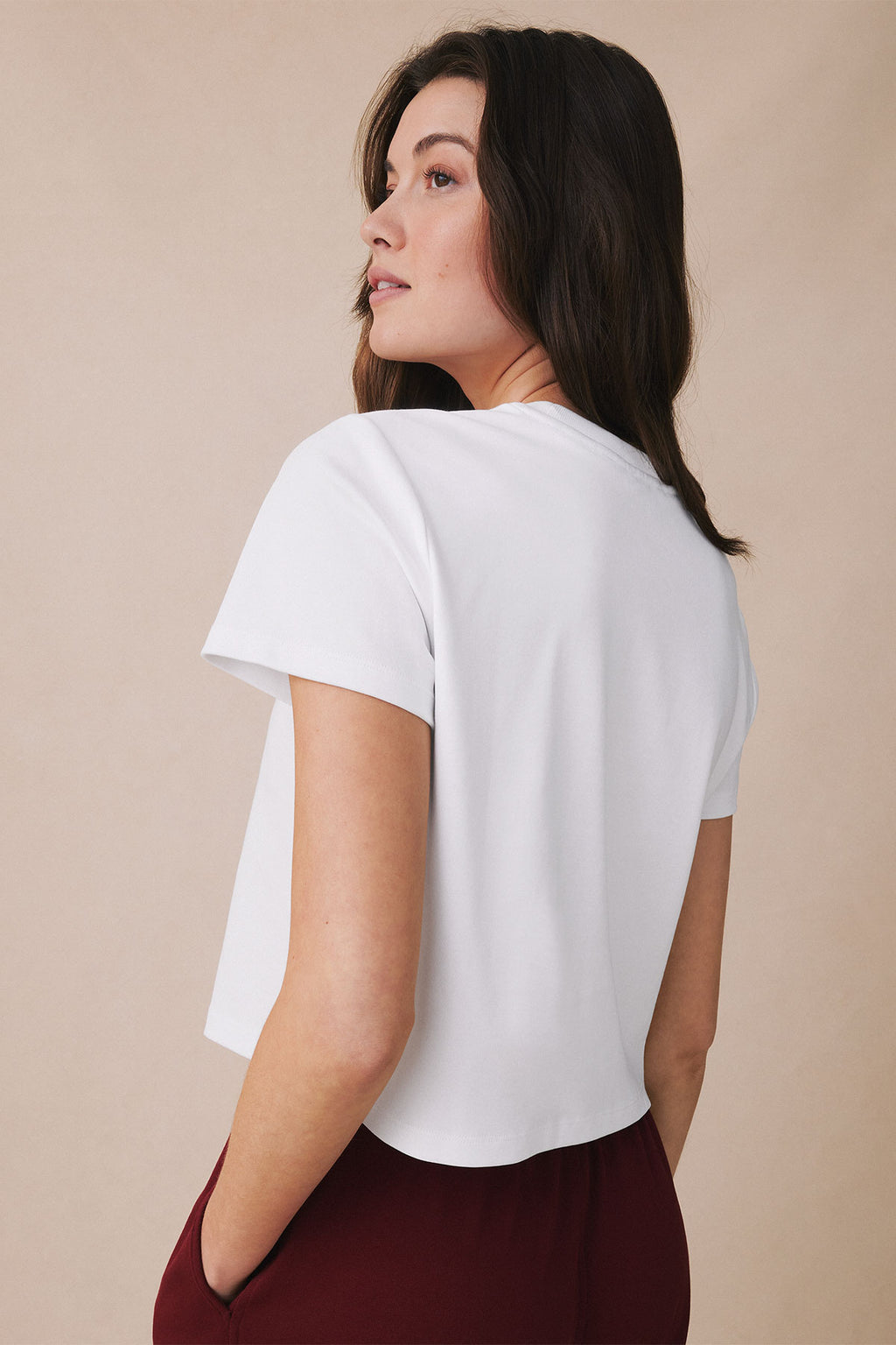 White short-sleeve t-shirt with boxy cut and relaxed fit shown on model from back angle.