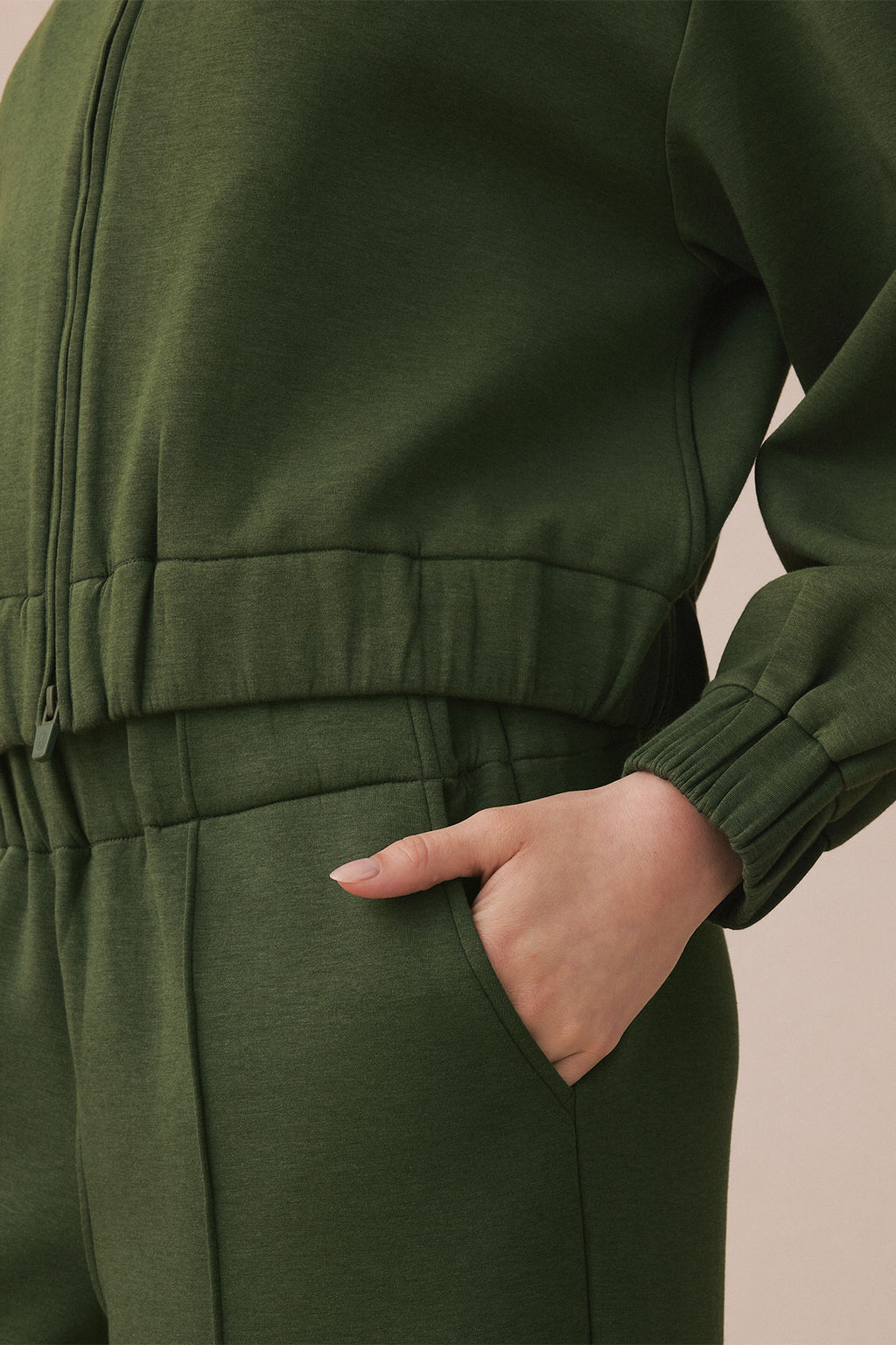 Cedar green jogger set with full-length sleeves, ribbed cuffs and waistband, and side pocket visible.