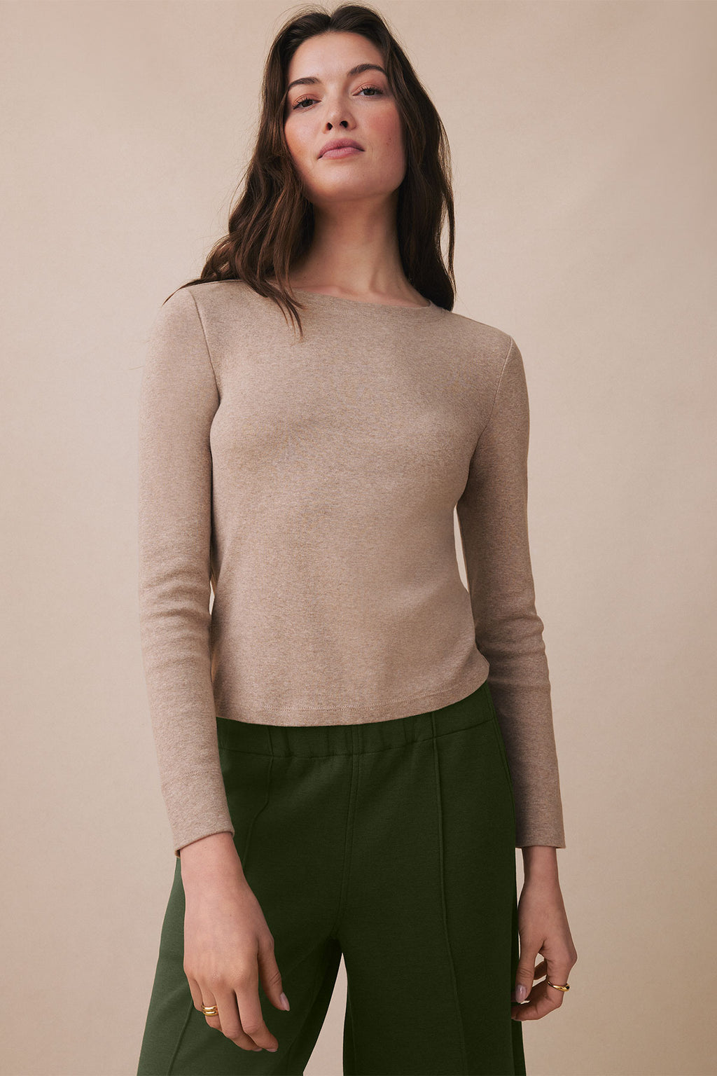 Woman wearing a fawn heather long sleeve tee with a crew neckline and fitted silhouette.