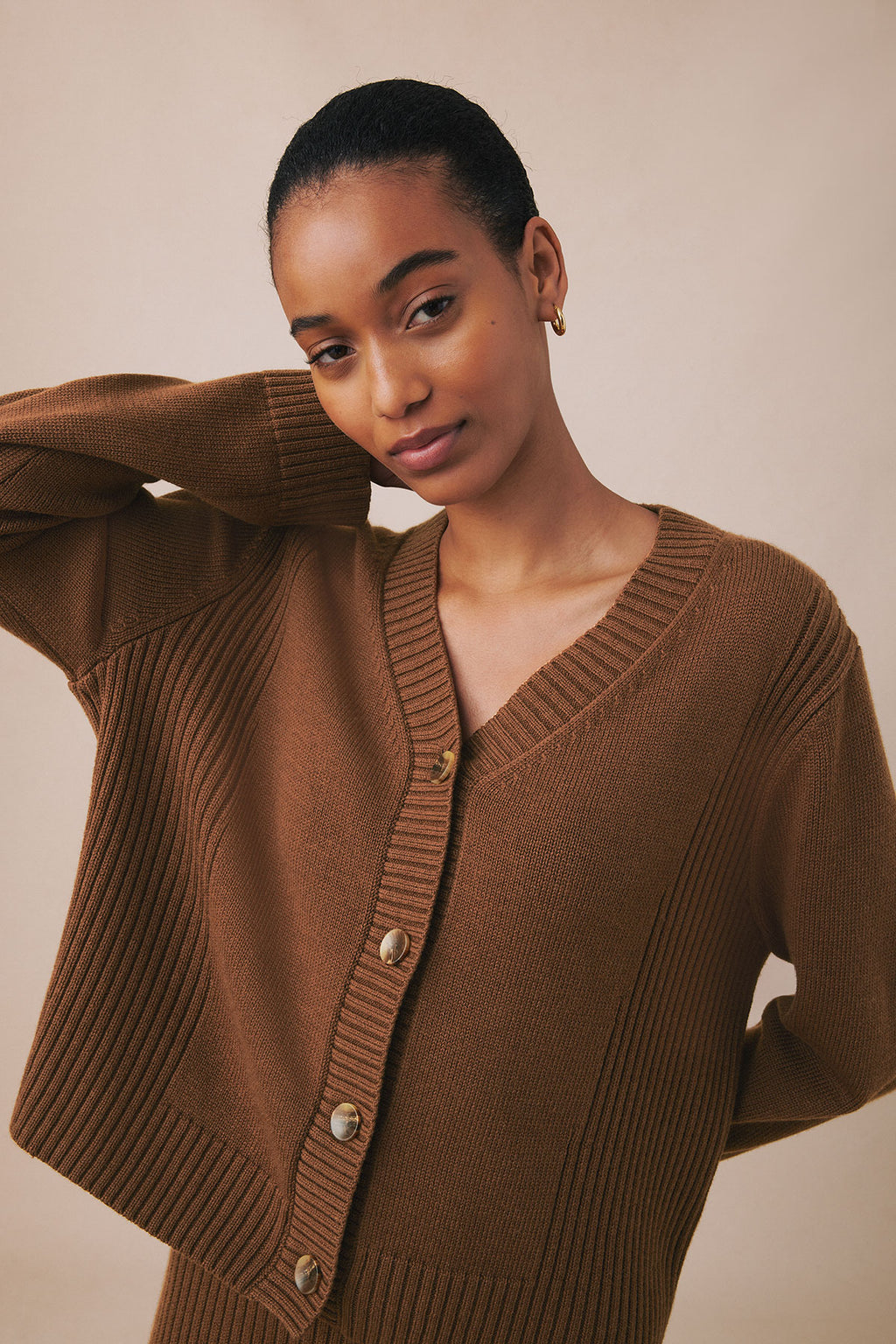 Cinnamon ribbed cardigan with button front and vertical ribbed texture detail on sleeves.
