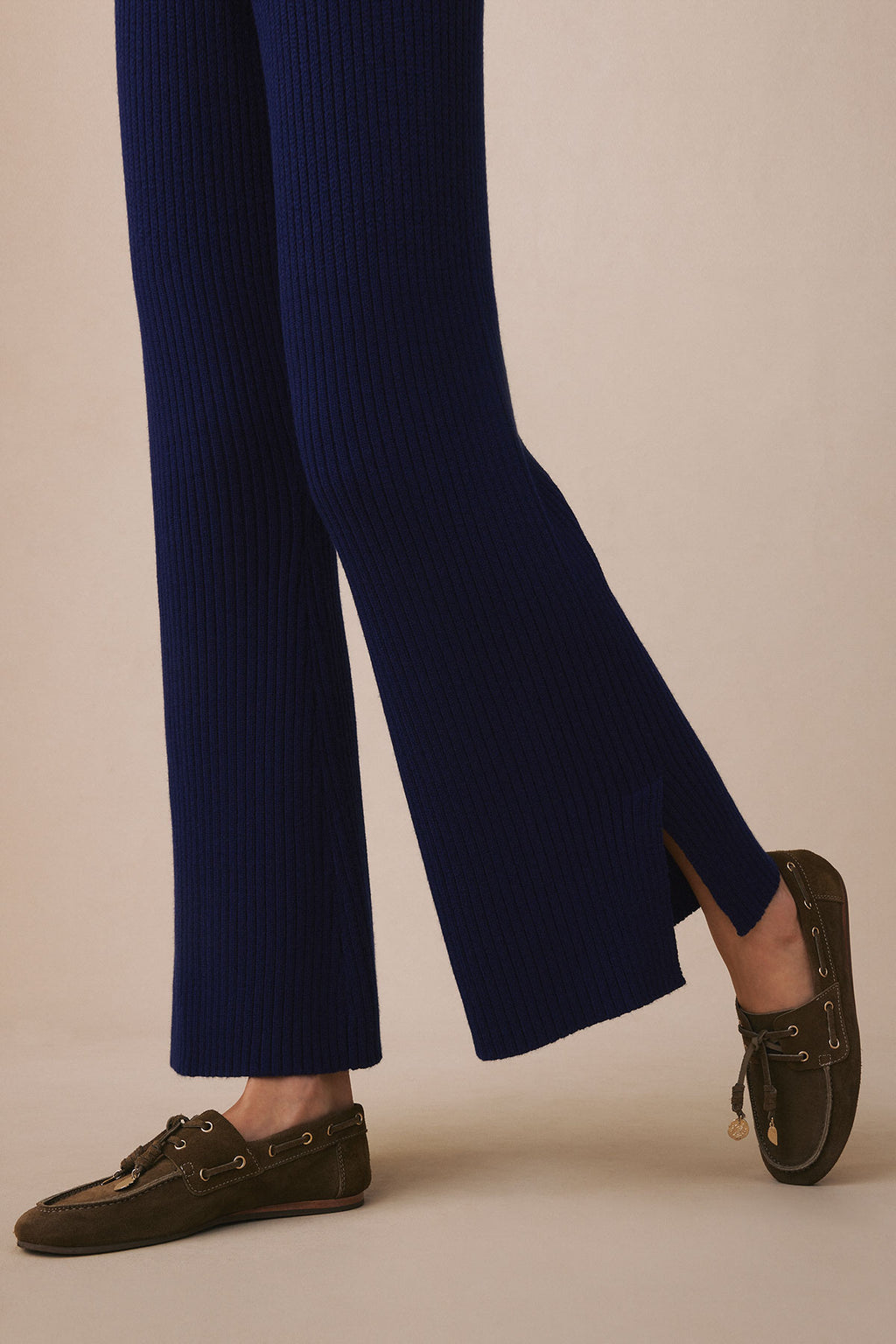 Navy ribbed flared pants with wide legs shown on model wearing olive suede boat shoes.