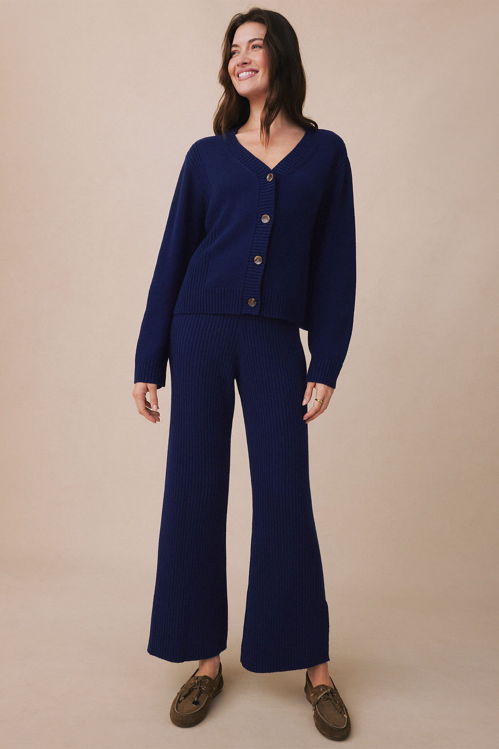 Woman wearing a dark blue ribbed cardigan and matching wide-leg ribbed pants with button-front closure.