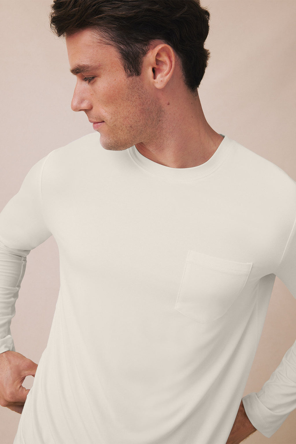 Man wearing cream long-sleeve t-shirt with crew neckline and chest pocket.