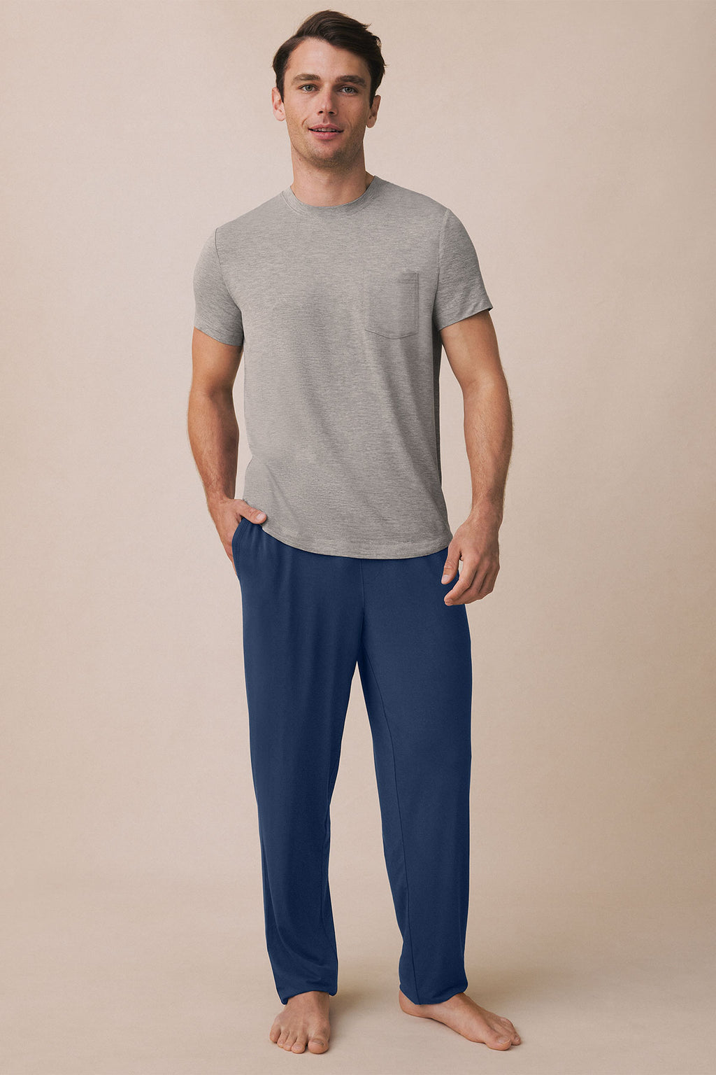 Man wearing gray short-sleeve t-shirt with chest pocket and navy pants.