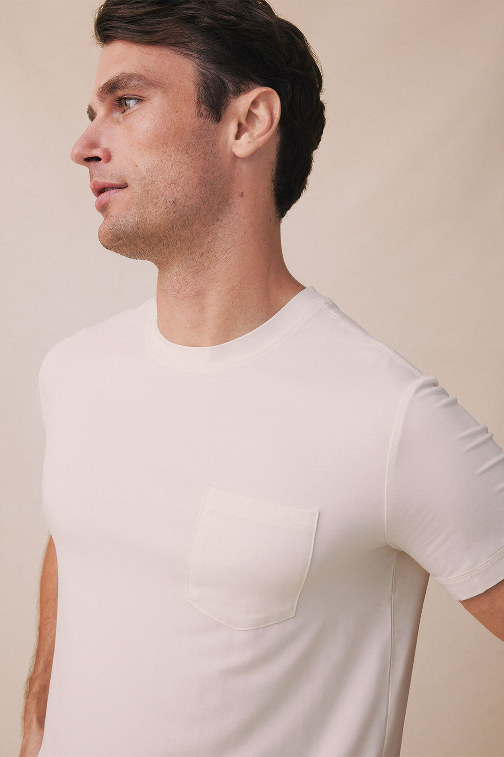 Man wearing light gray short-sleeve t-shirt with chest pocket, shown in profile view.