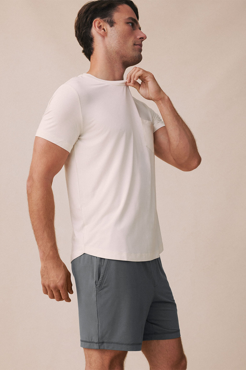 Man wearing cream short-sleeve t-shirt and shadow gray shorts.
