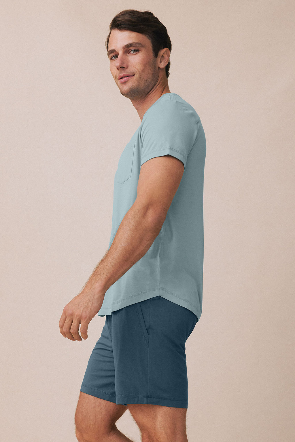 Man wearing light blue short-sleeve t-shirt and dark blue shorts.