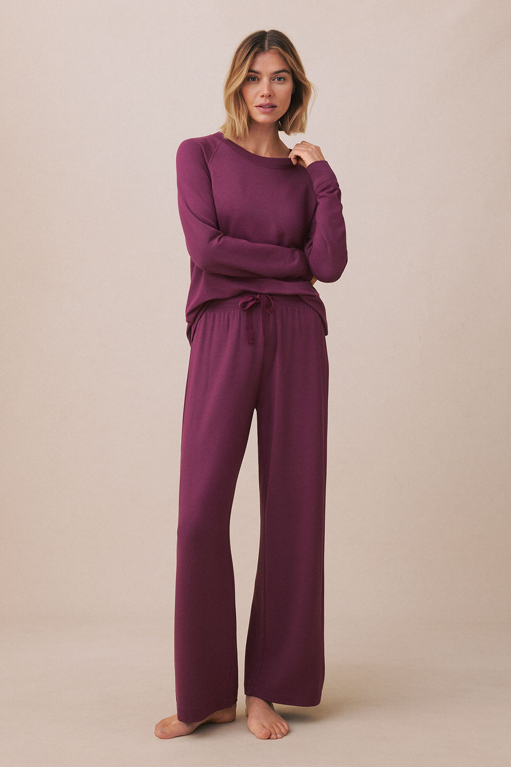 Woman wearing a fig-colored long-sleeve pullover and matching wide-leg pants with drawstring waist.