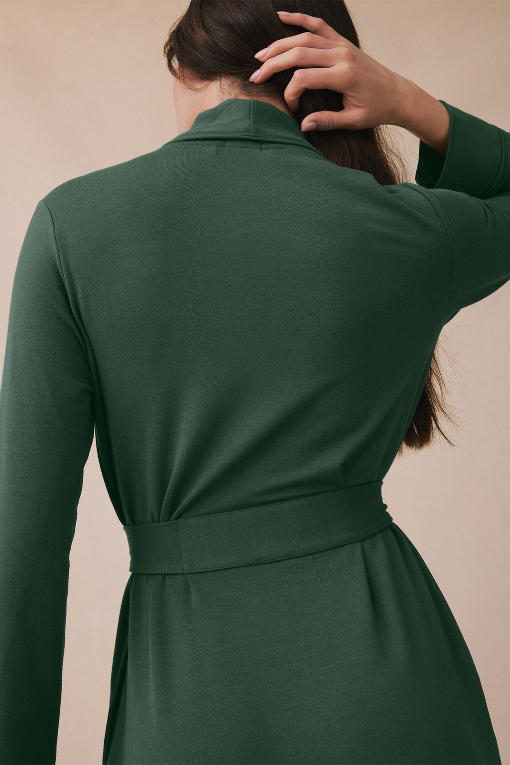 Person wearing trekking green robe shown from behind, displaying collar, long sleeves, and tie waist.