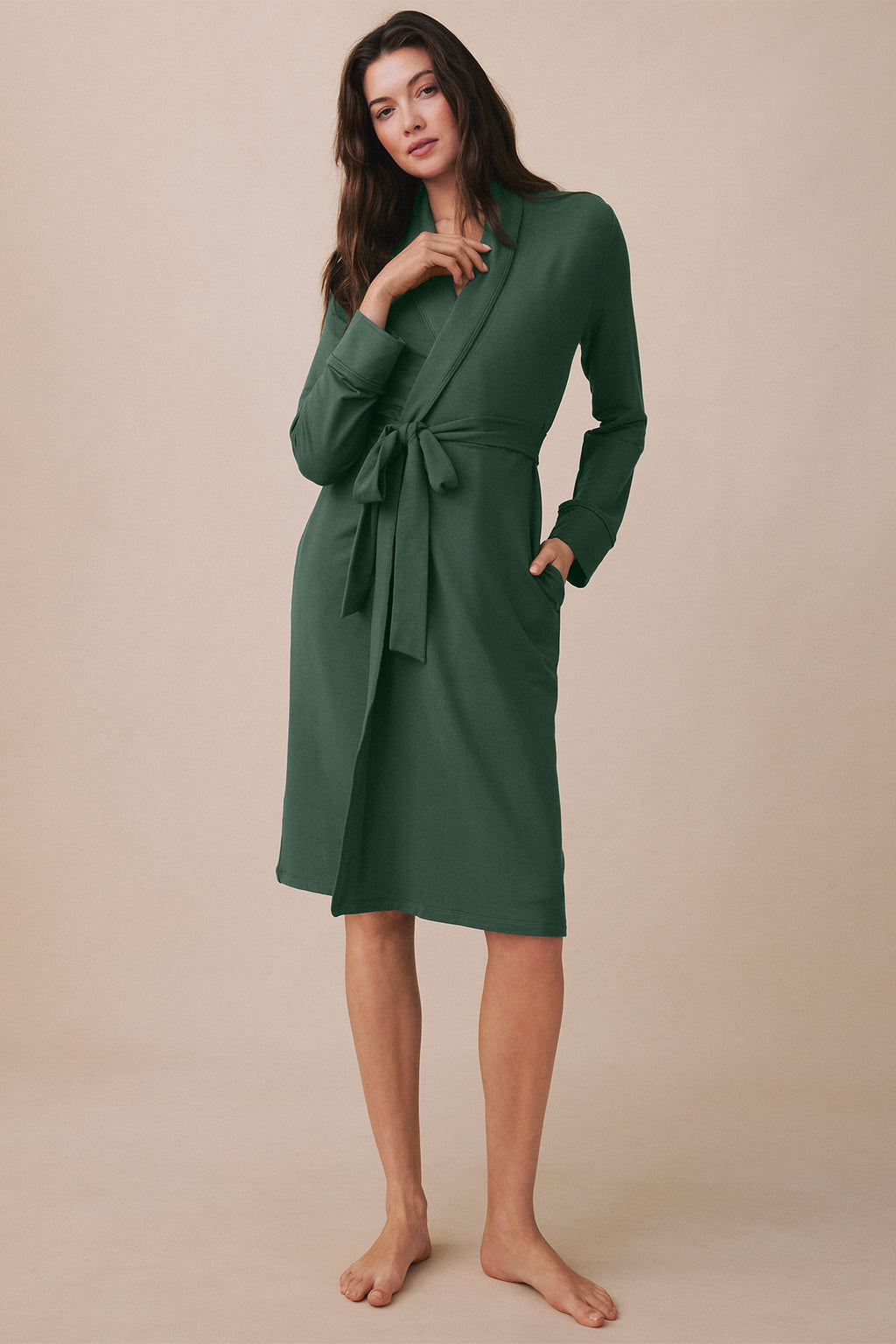 Woman wearing a trekking green wrap robe with long sleeves, tie waist, and knee-length cut.