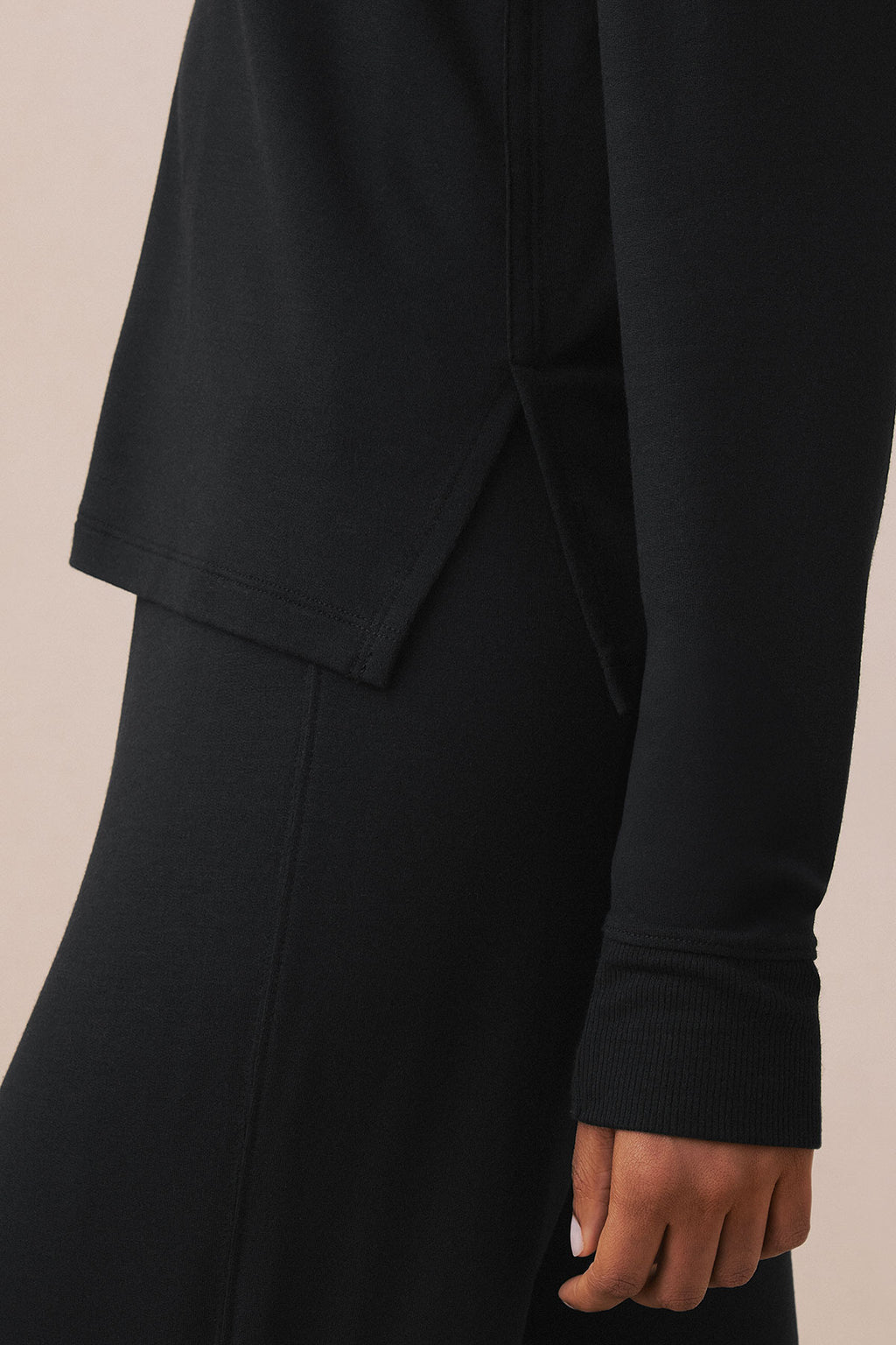 Black long-sleeve top with V-neckline and ribbed cuffs.