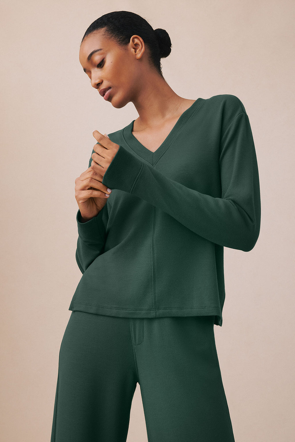 Woman wearing trekking green V-neck long-sleeve top and matching pants.