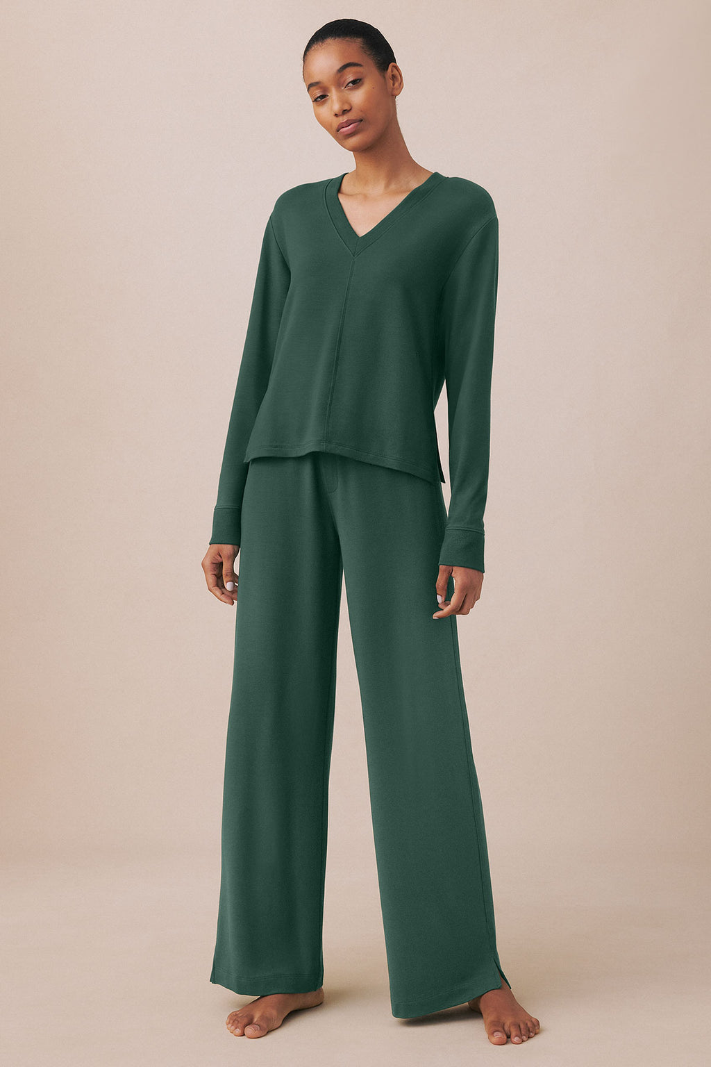 Woman wearing a trekking green V-neck long-sleeve top and matching wide-leg pants.