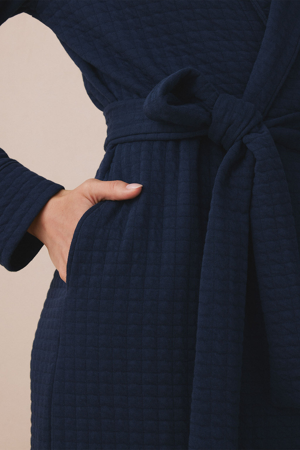 Navy textured robe with tie waist and front pocket, shown on model with hand in pocket.