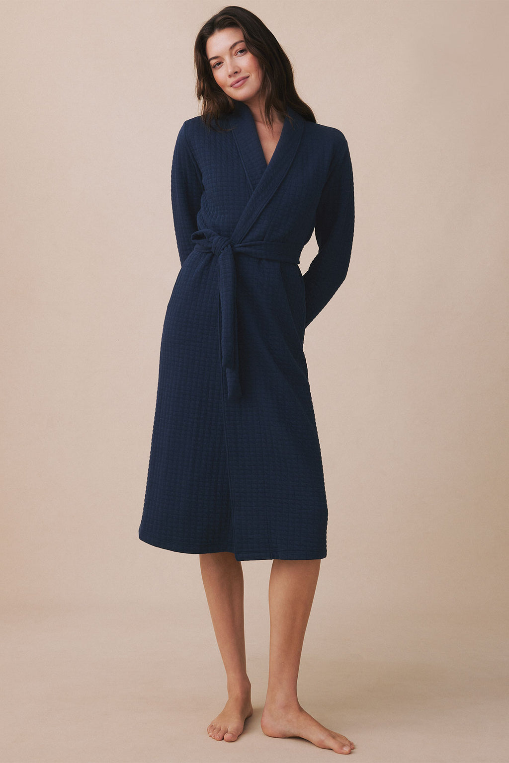 Navy waffle-textured robe with wrap front, tie waist, long sleeves, and knee-length cut.