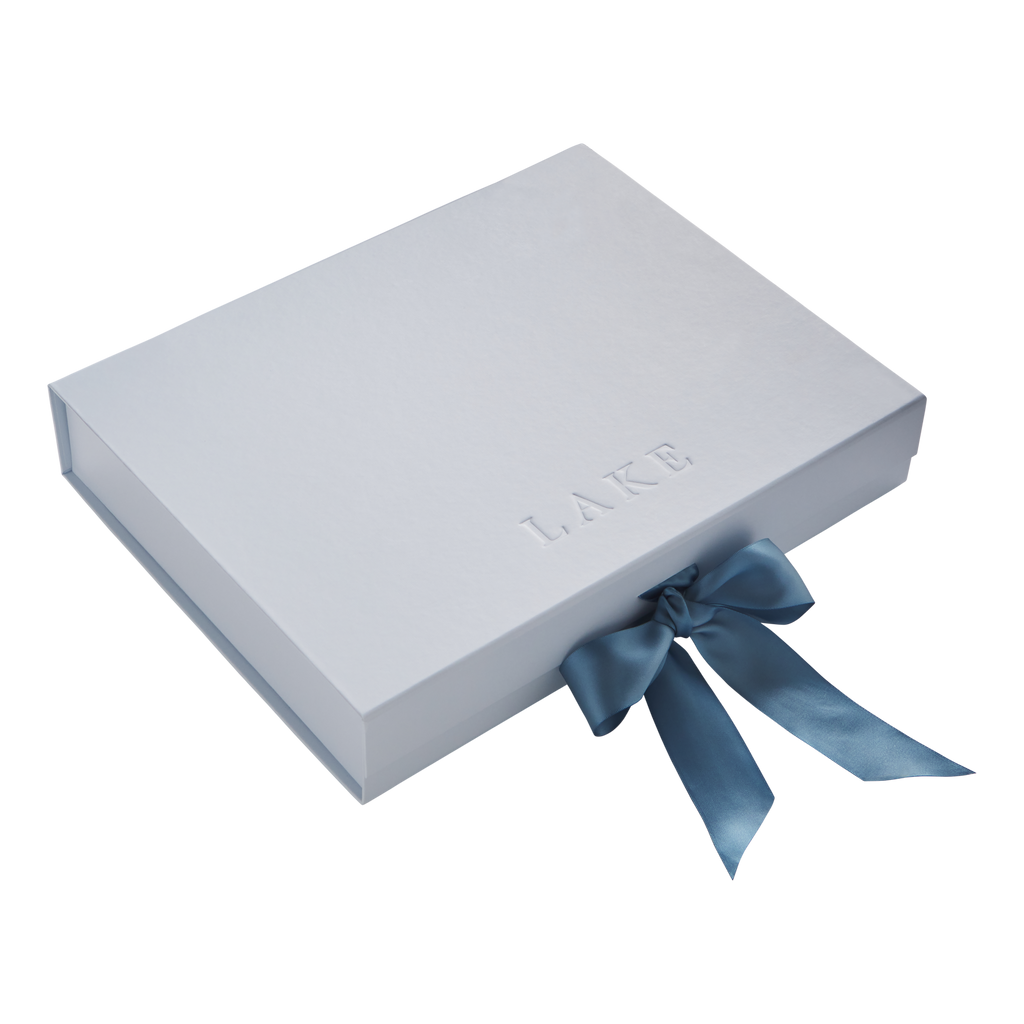 Light gray rigid box with embossed text and blue ribbon bow closure.