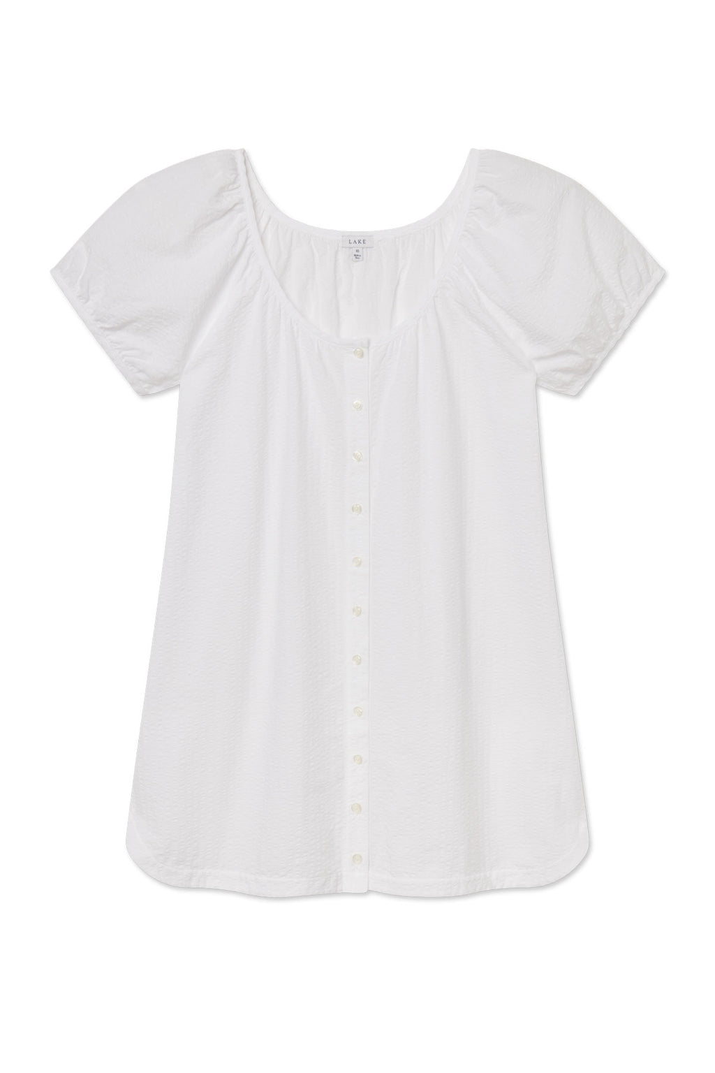 The Charlie Nightgown in White Seersucker, featuring a loose fit, short sleeves, scoop neckline, and button placket, is shown laid flat on a white background.