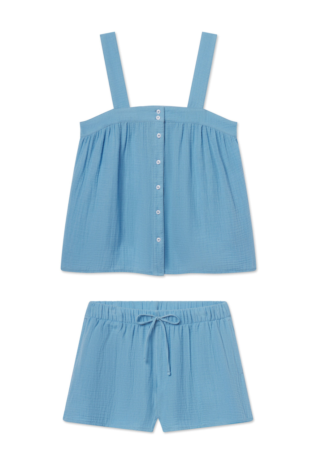 The Hamptons Shorts Set in Serene Blue is a light blue cotton pajama set featuring a sleeveless, button-front top and elastic waist shorts made from textured gauze—perfect for hot sleepers.