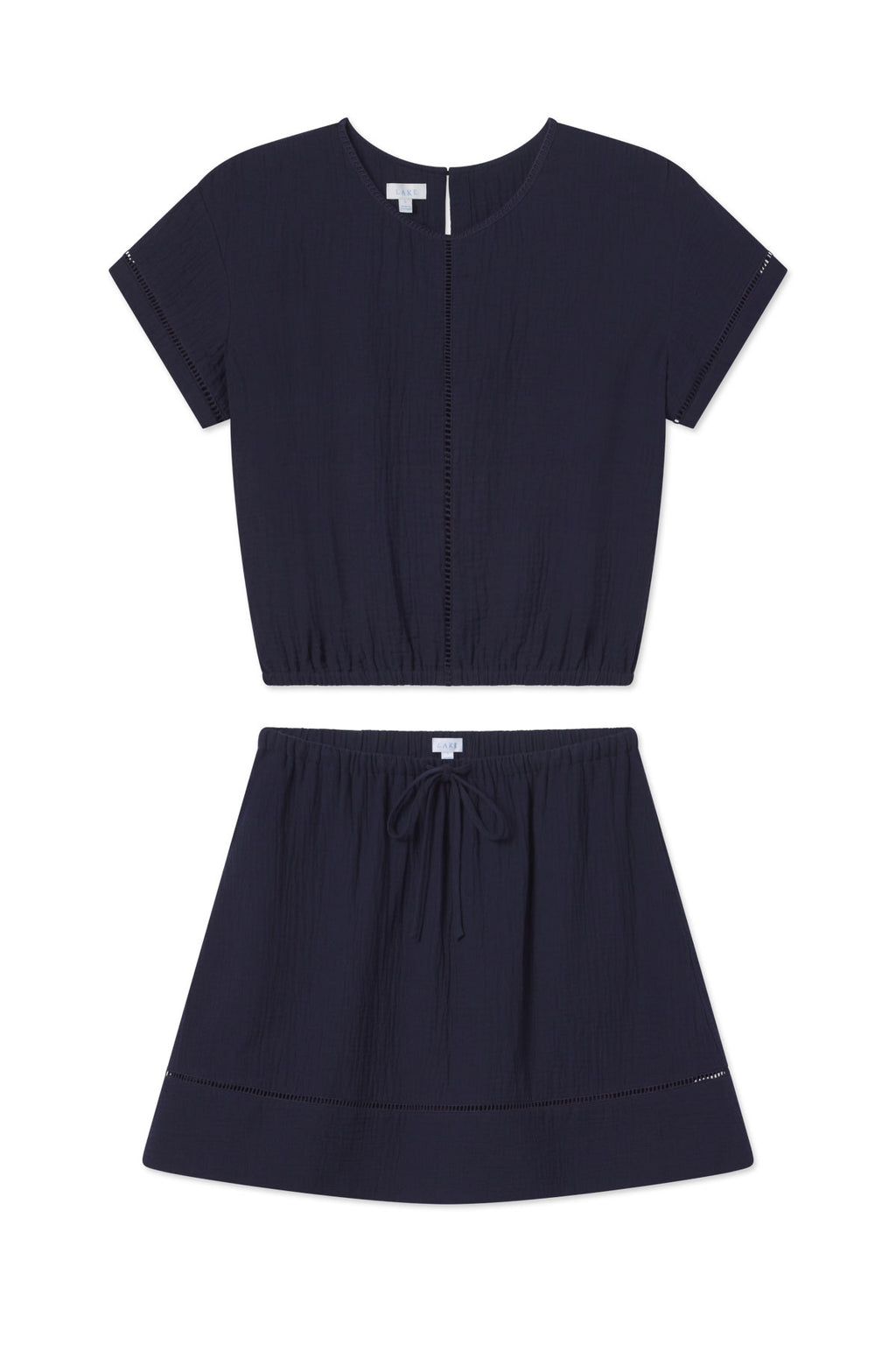 The Cabana Skirt Set in Maritime features a short-sleeve, crew neck cropped top and an above-the-knee flowy skirt with pockets and a drawstring waist, both made from lightweight textured fabric.