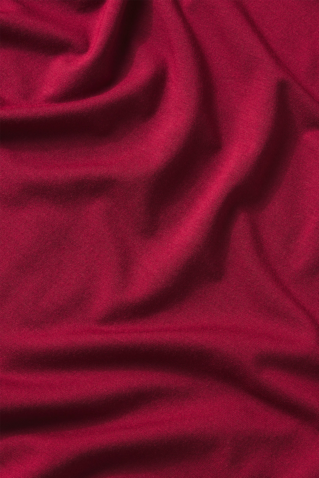 A close-up of the smooth texture and soft folds of the DreamModal Ribbon Short-Long Set in Burgundy, highlighting its rich burgundy color and ribbon tie accent.