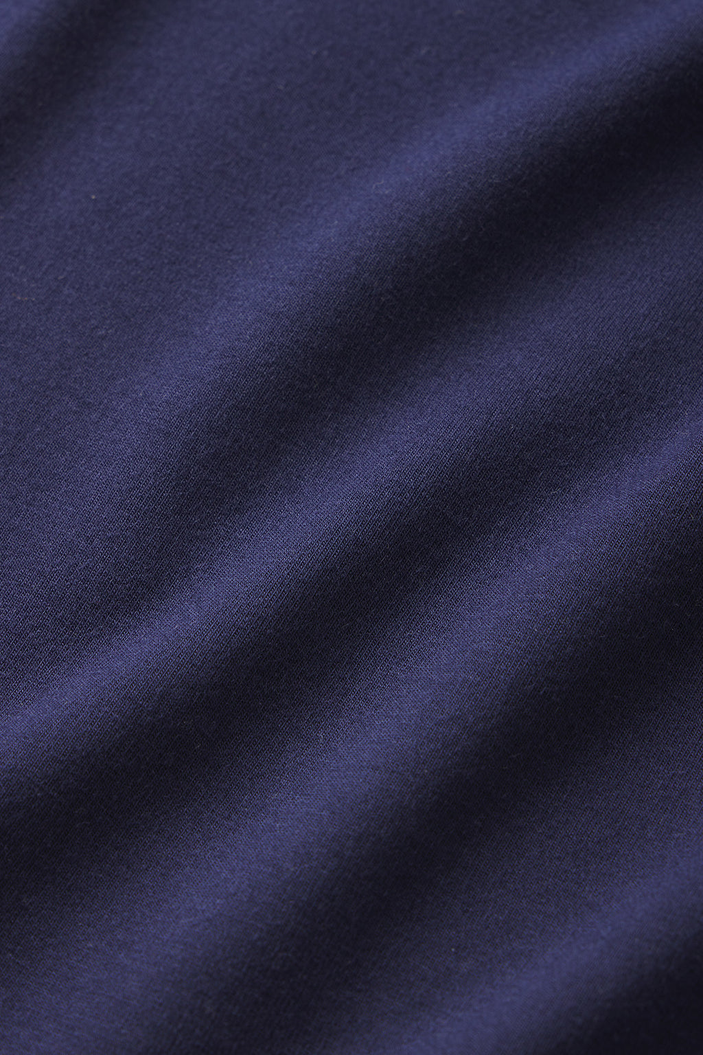 Close-up of the smooth, dark blue English Navy fabric from the DreamModal Cami Shorts Set, featuring gentle folds and a soft texture that highlights its rich color and fine weave.