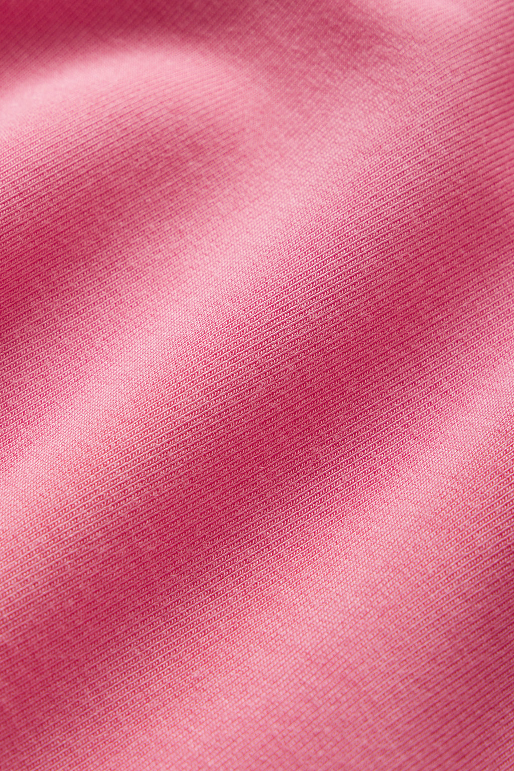 Close-up of the Relax Shorts Set in Sunkissed Coral, highlighting its soft fabric, fine texture, and gentle folds that create subtle shadows and highlights.