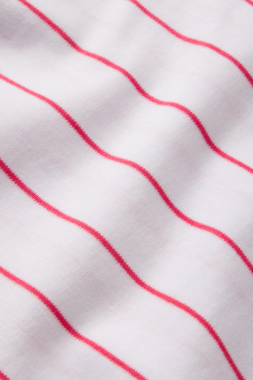 Close-up of the Pima Shorts Set in Geranium Boating Stripe, featuring soft white Pima cotton with smooth, evenly spaced wavy red stripes running horizontally across the fabric.