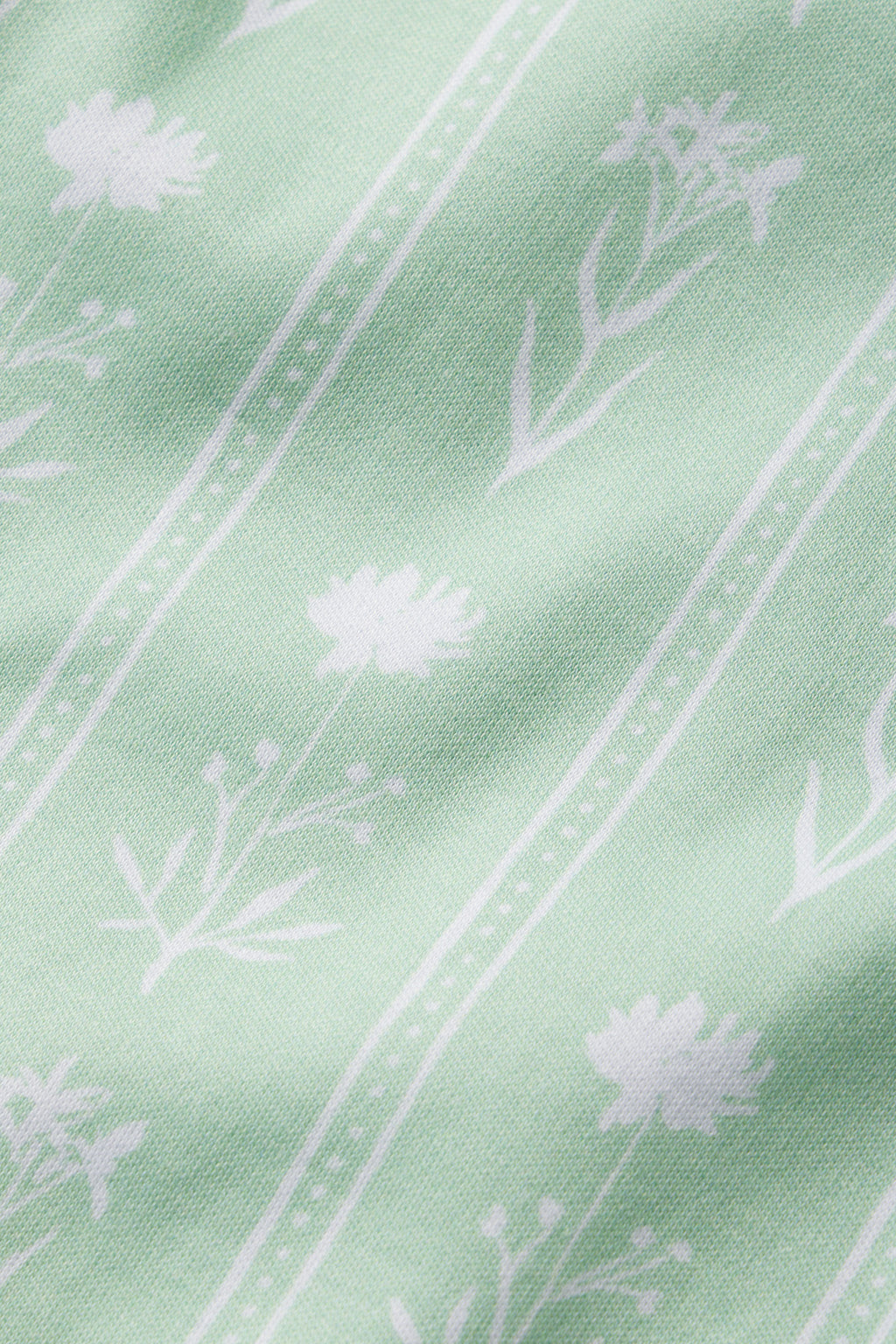 The Pima Short Robe in Parisian Green Watercolor Stems features a soft, decorative design of simple white floral patterns and thin dotted stripes on 100% Pima cotton.