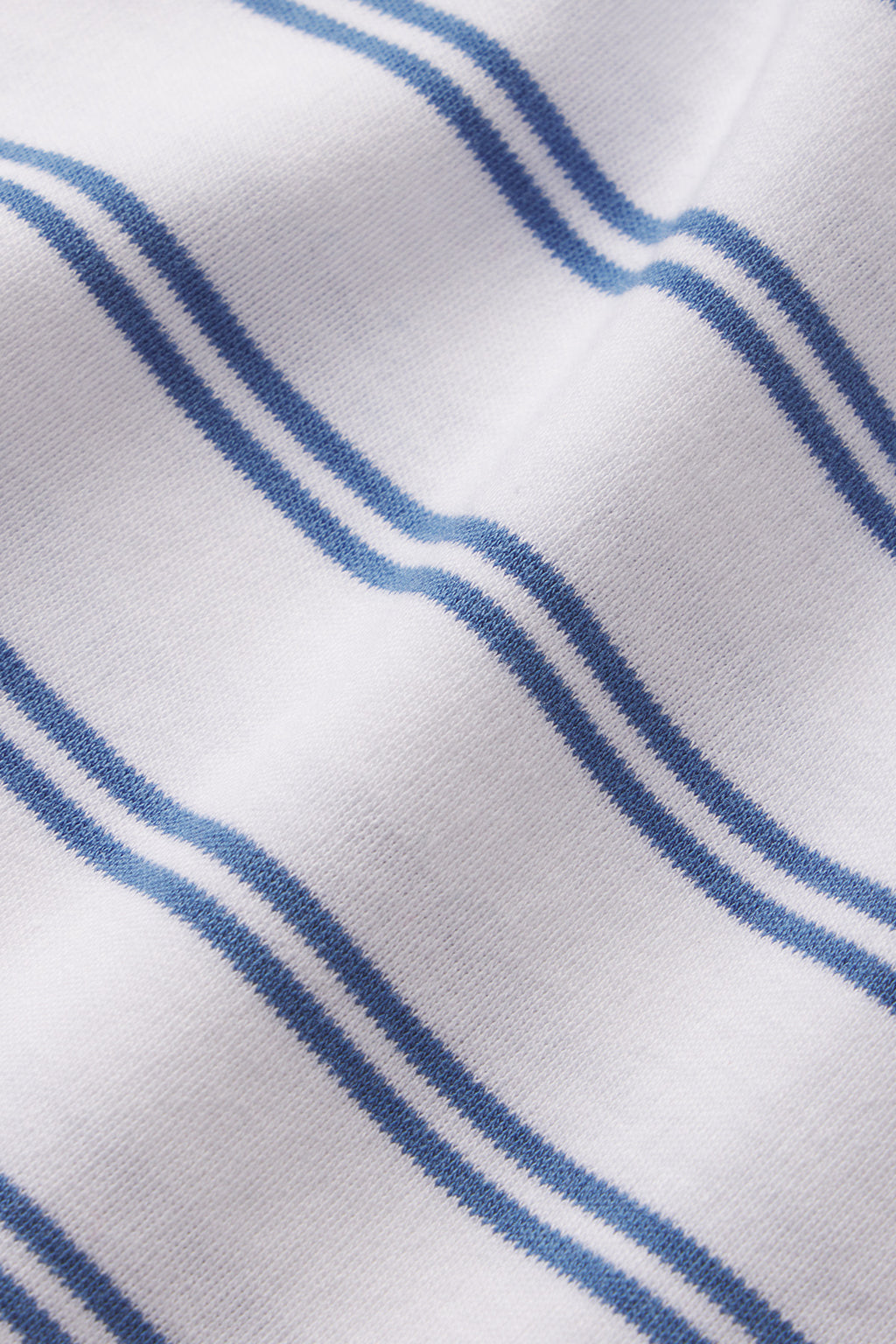 Close-up of the Pima Crew Shorts Set in Seaport Tidal Stripe—white Pima cotton features parallel blue stripes that highlight the fabric’s soft texture and smooth, gently wavy appearance.